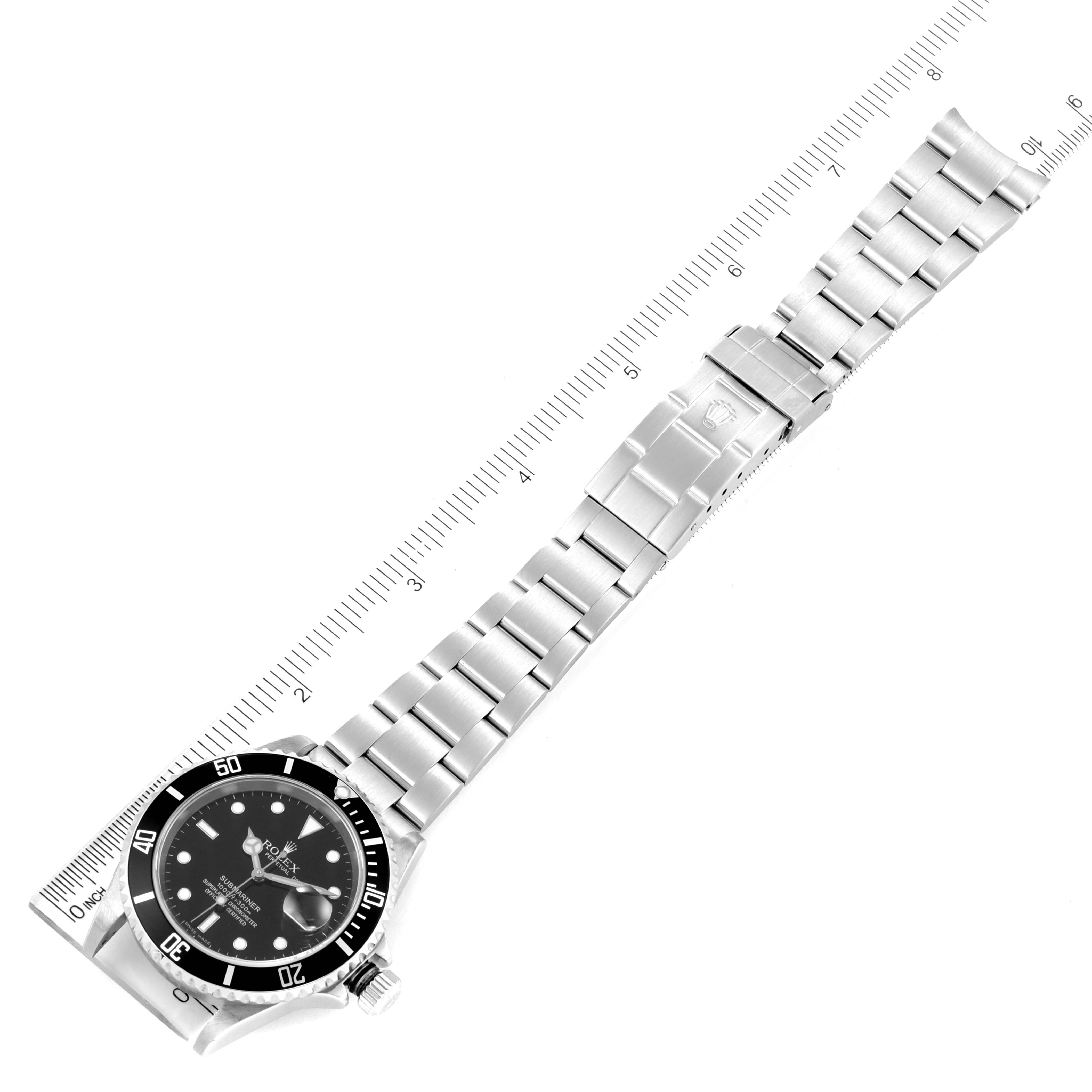 The image shows a top-down view of a Rolex Submariner 16610 Men
s Stainless Steel Black Dial 16610 Men
s Stainless Steel Black Dial watch, including the bezel, dial, bracelet, and ruler for scale.