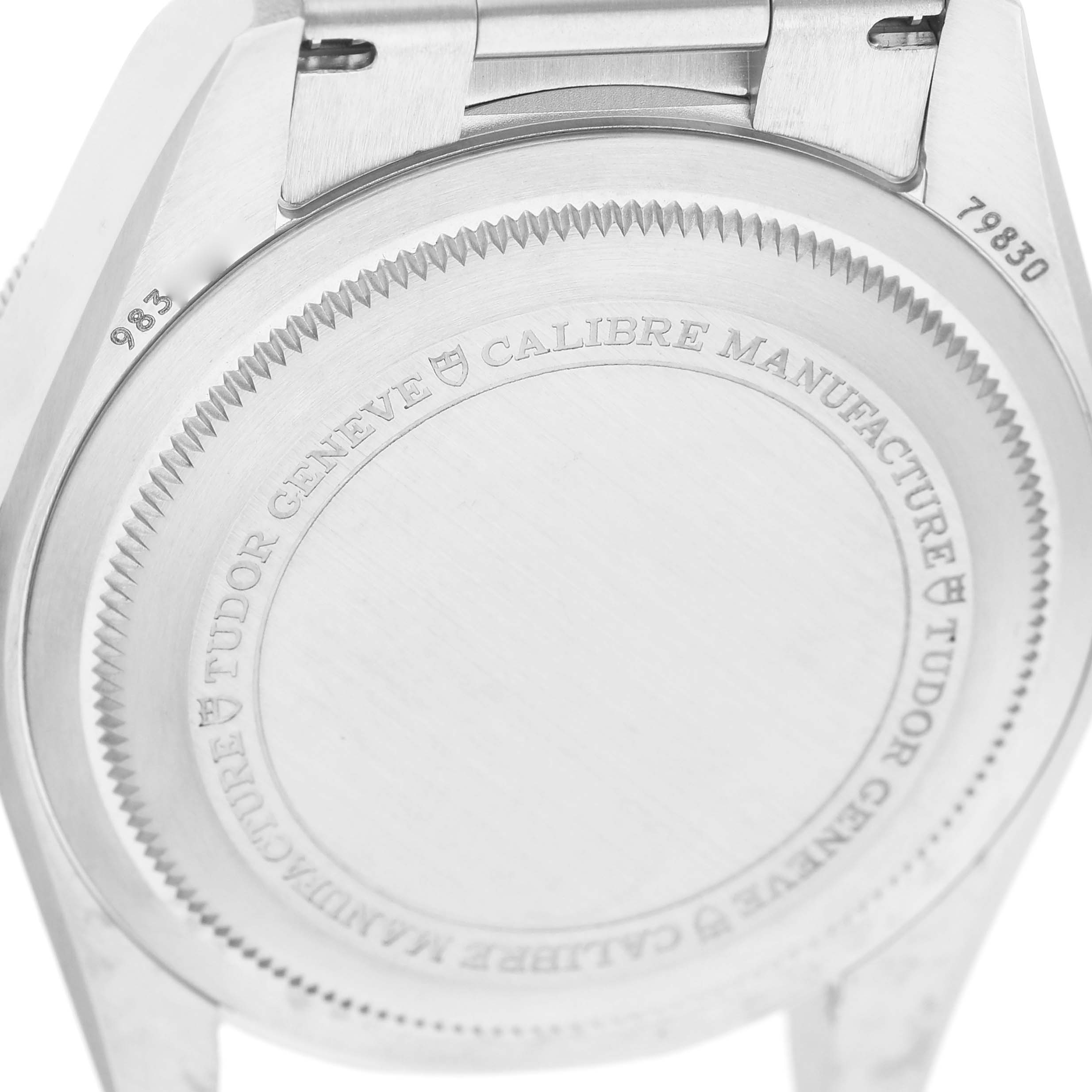 The image shows the back case of the Tudor Heritage Black Bay 79830RB Men's Stainless Steel Black Dial watch, highlighting engravings and part of the clasp.