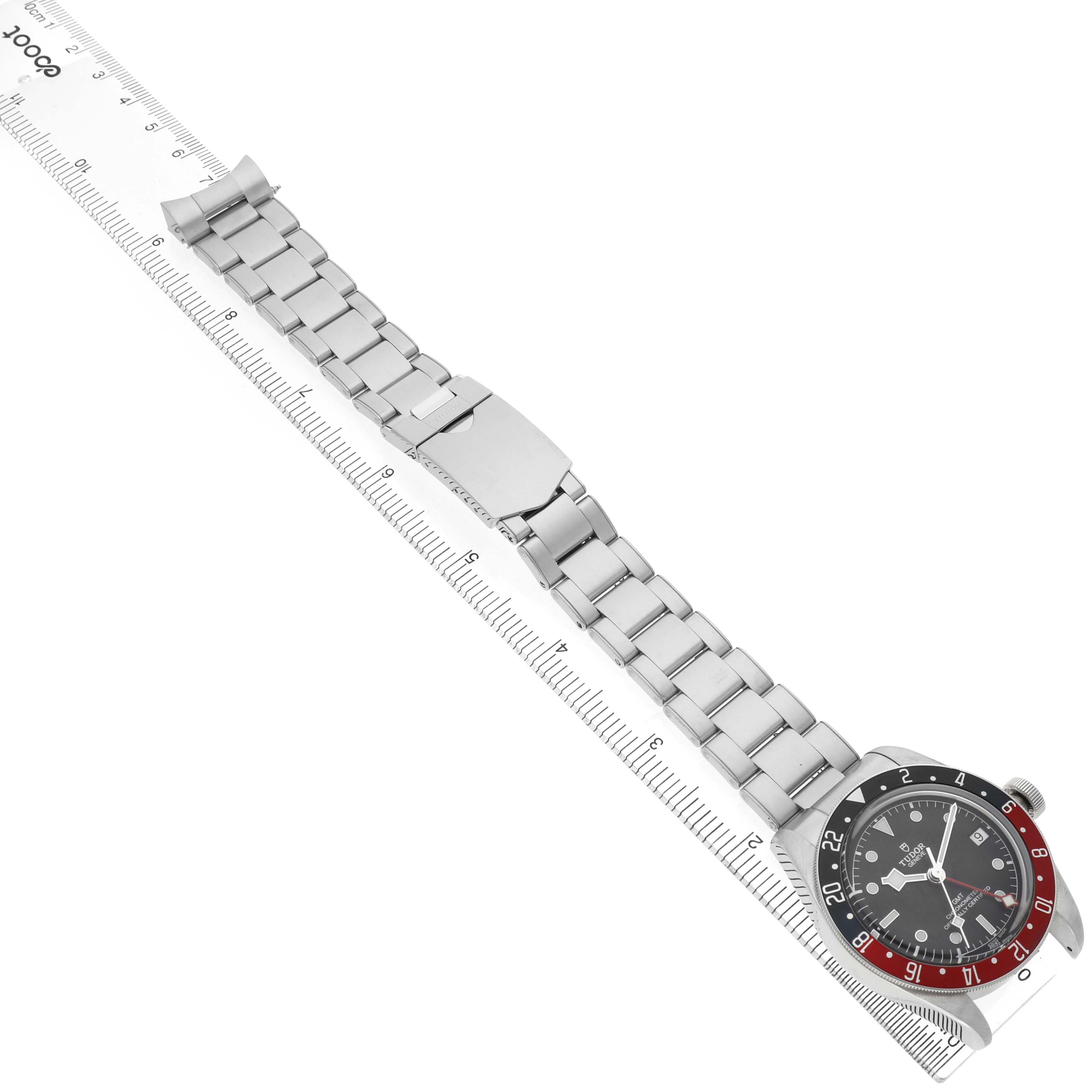 The Tudor Heritage Black Bay 79830RB Men's Stainless Steel Black Dial is shown from a top-down angle, displaying the bezel, dial, and metal bracelet.