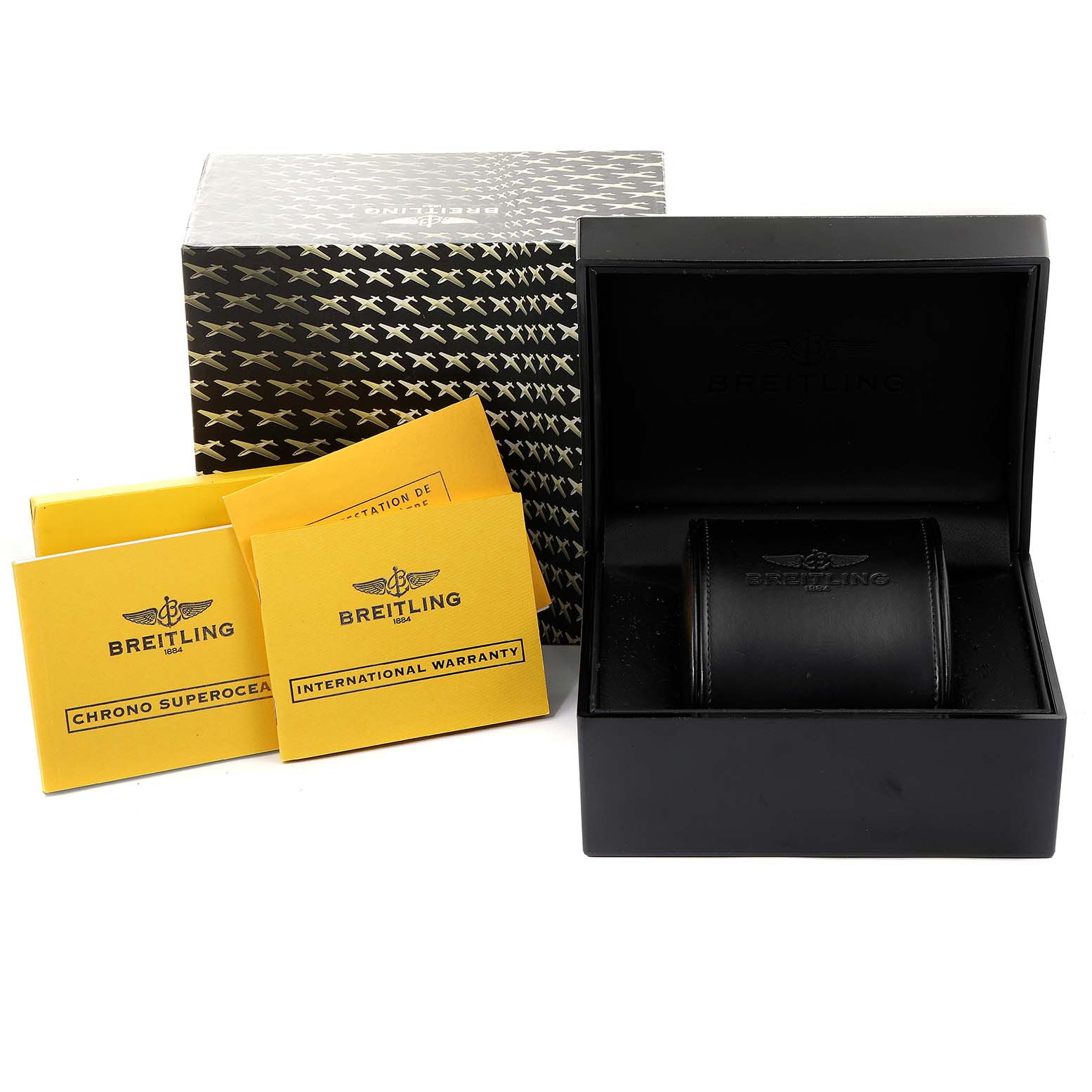 This image shows a Breitling Superocean A13340 Men
s Stainless Steel Black Dial A13340 Men
s Stainless Steel Black Dial watch box, a patterned outer box, and two yellow booklets: Chrono Superocean and International Warranty.
