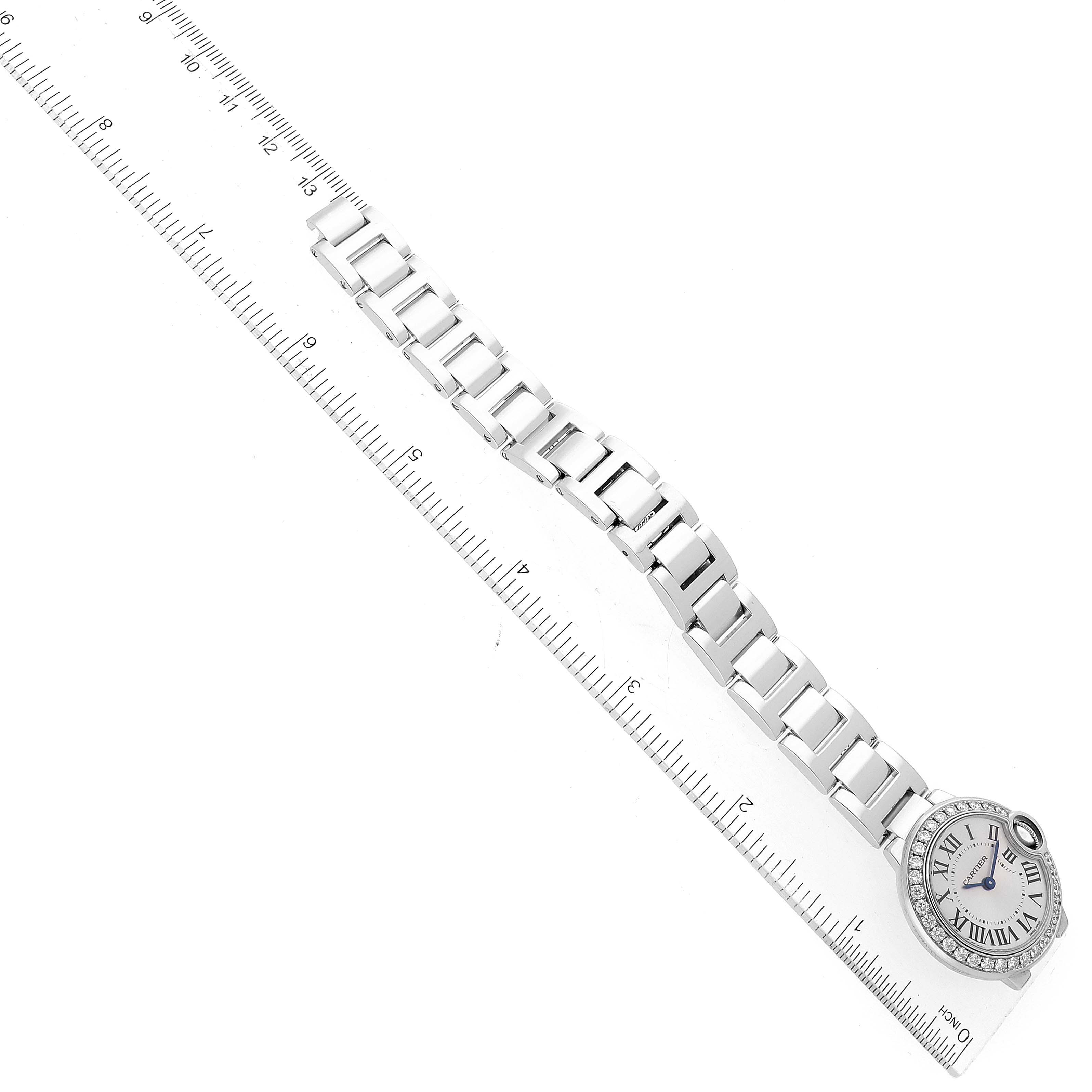 The image shows an overhead view of a Cartier Ballon Bleu WE9003Z3 Women's White Gold Silver Dial WE9003Z3 Women's White Gold Silver Dial watch, including its dial and metal link bracelet, alongside a ruler for scale.