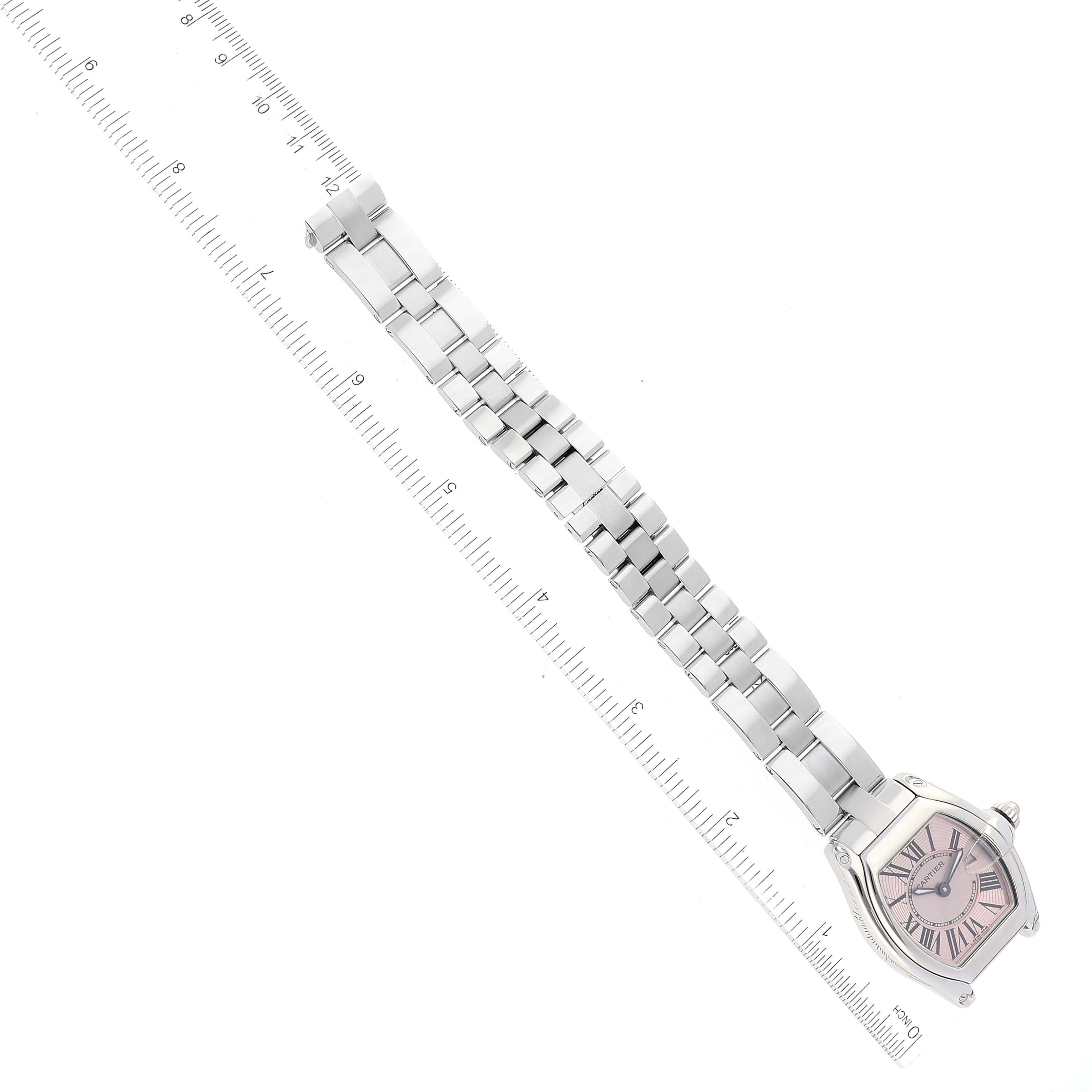 The image displays a Cartier Roadster W62017V3 Women's Stainless Steel Pink Dial W62017V3 Women's Stainless Steel Pink Dial watch with a linked bracelet, viewed from a top-down angle alongside a ruler.