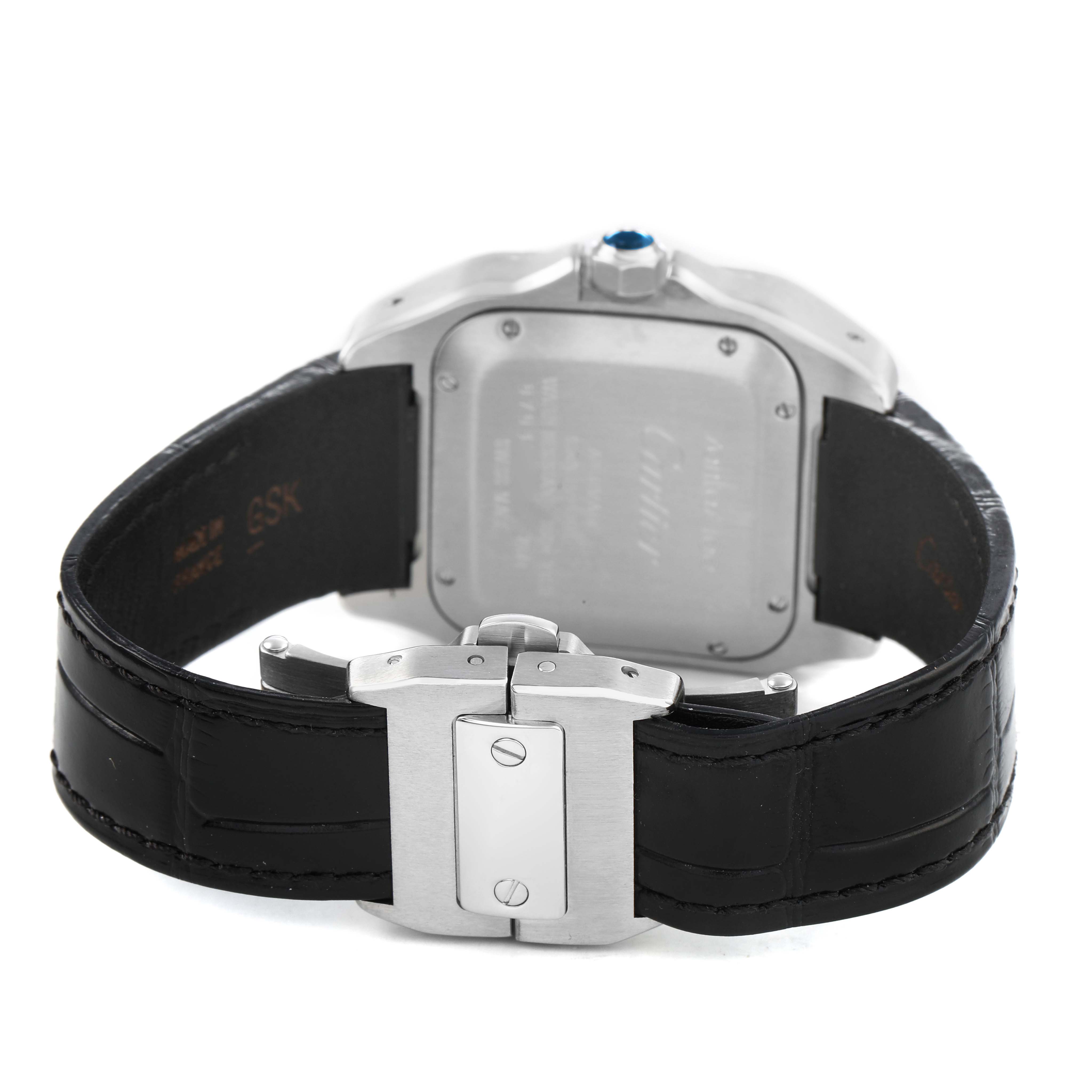 The image shows the Cartier Santos W20106X8 Men's Stainless Steel Silver Dial watch from a rear angle, highlighting the case back, crown, and leather strap with a clasp.