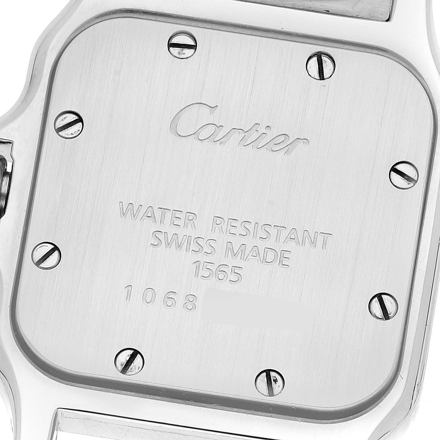 The image shows the back casing of a Santos model watch by Cartier, highlighting the engraved brand and model details.