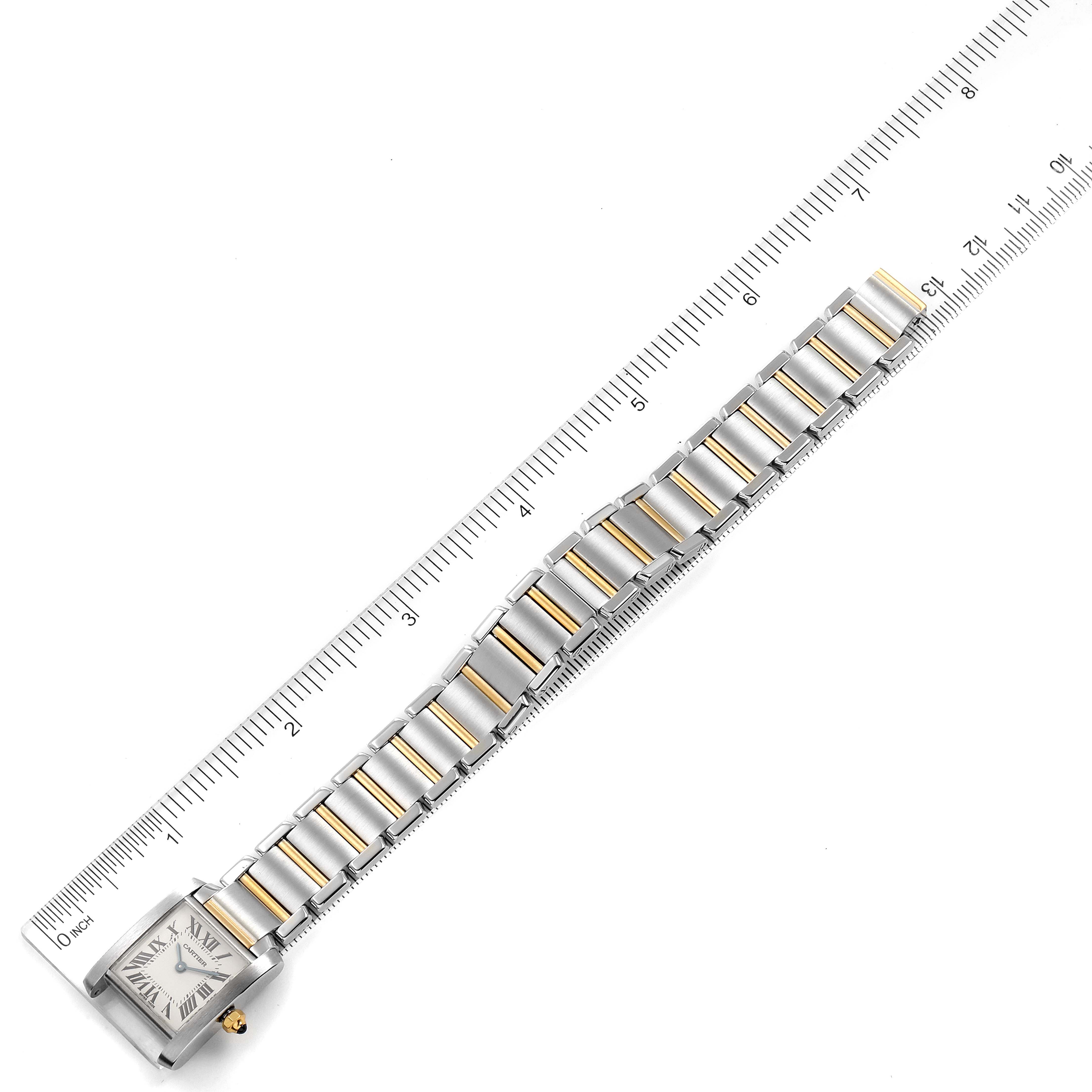 The image shows a top-down view of a Cartier Tank Française watch with a ruler alongside for scale.