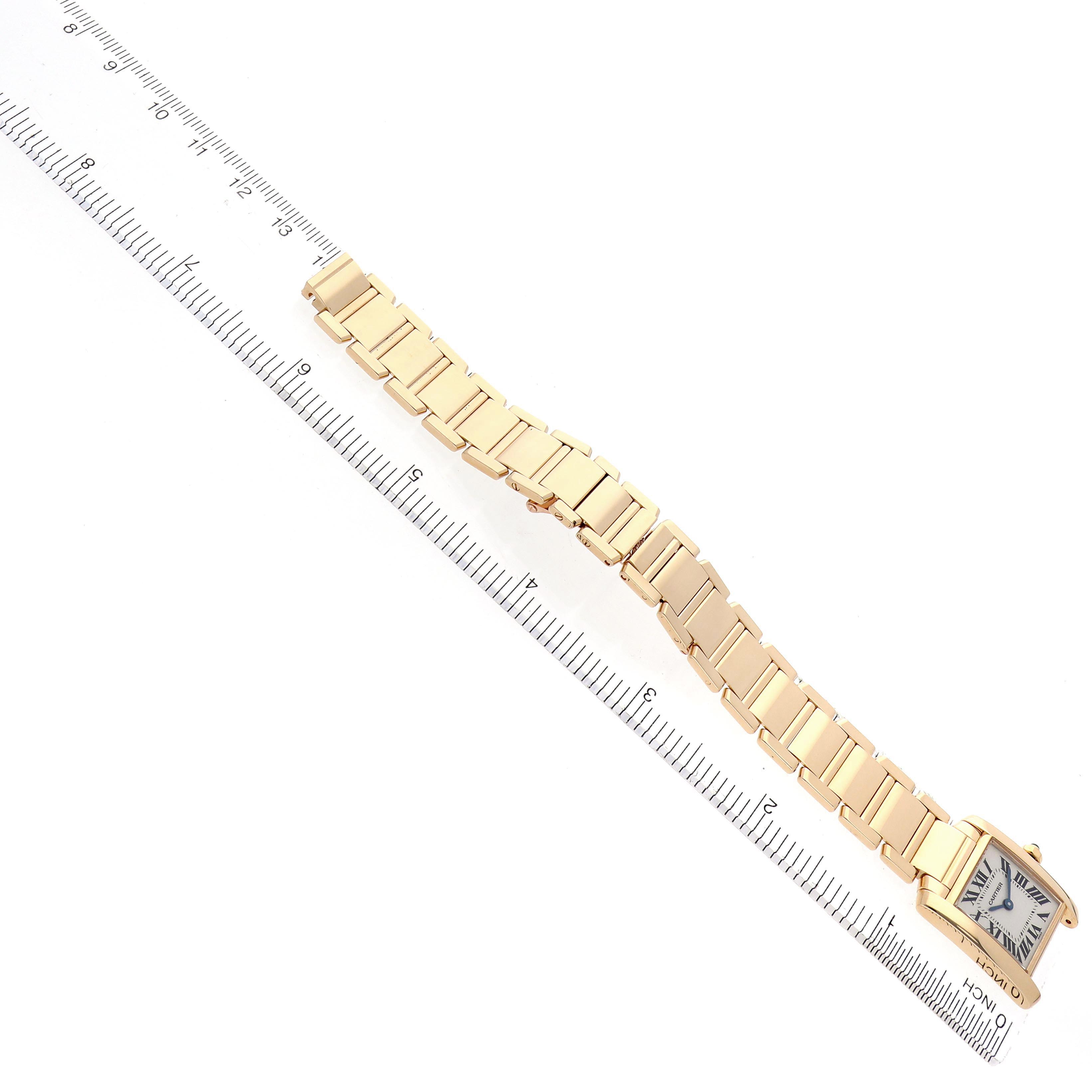 The Cartier Tank Francaise W50002N2 Women
s Yellow Gold Silver Dial W50002N2 Women
s Yellow Gold Silver Dial watch is shown from a top view, highlighting its bracelet and square case next to a ruler.