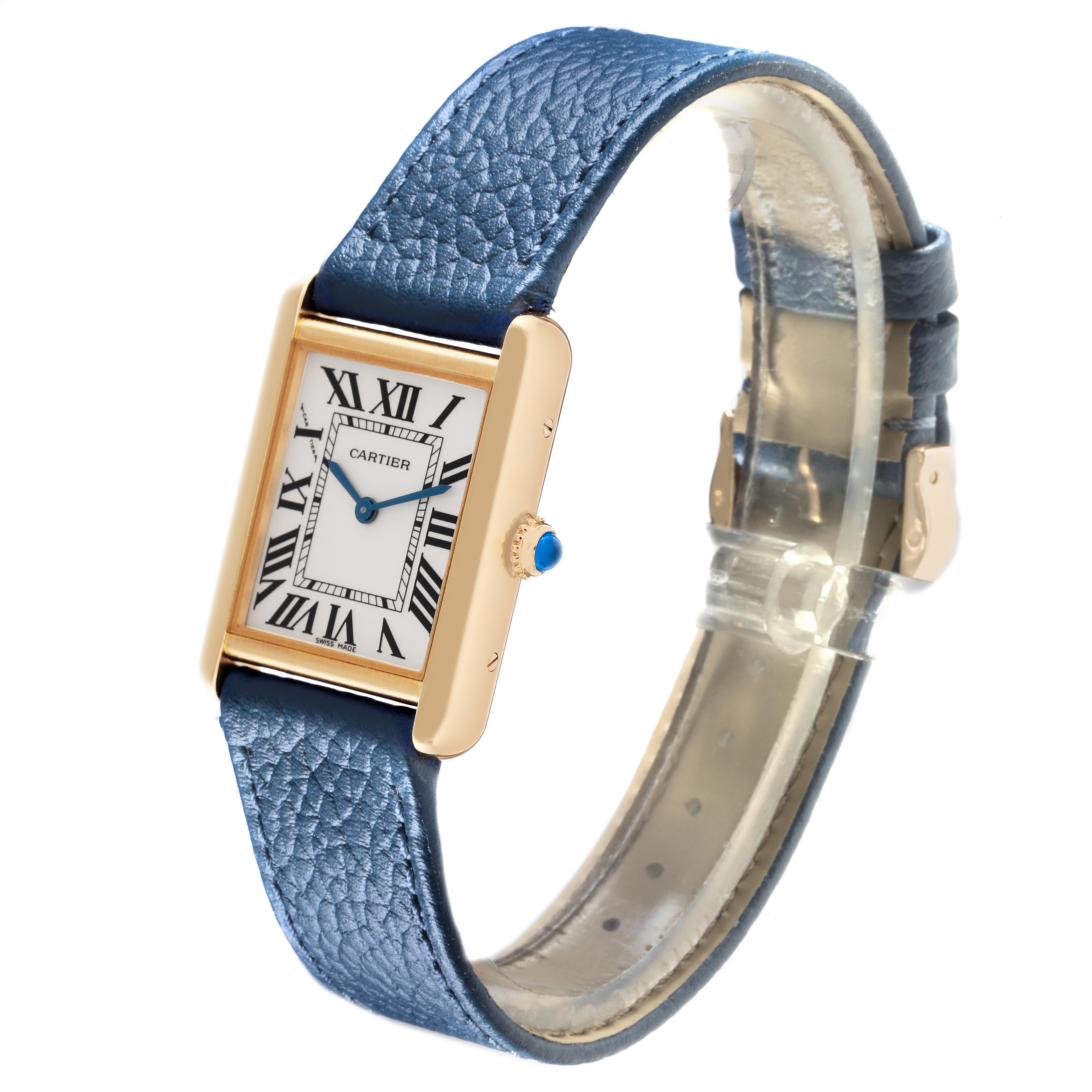 The Cartier Tank Solo W5200002 Women
s Steel and Gold (two tone) Silver Dial W5200002 Women
s Steel and Gold (two tone) Silver Dial watch is viewed at an angle showing its rectangular face, blue leather strap, and blue crown gem.