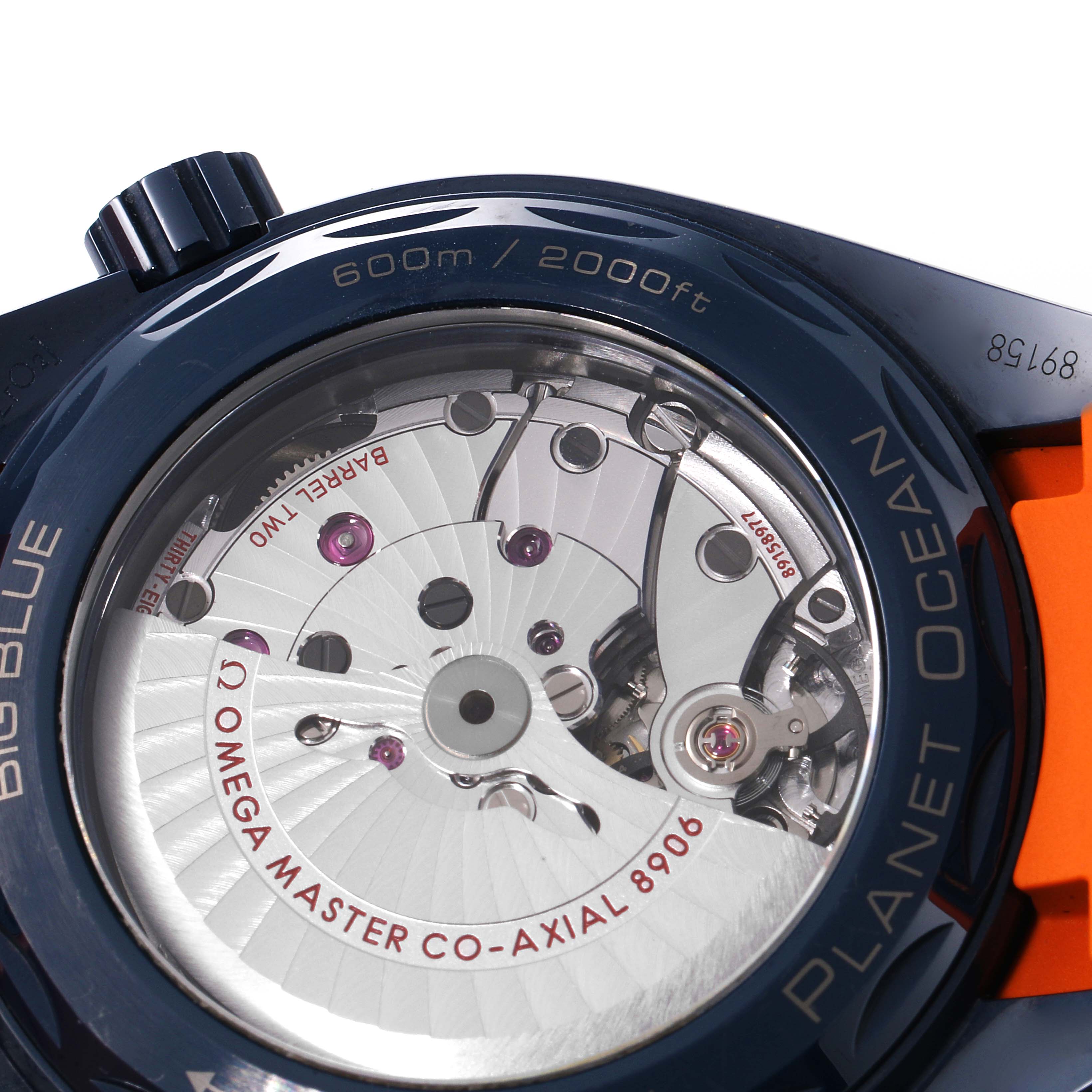 The image shows the back of the Omega Planet Ocean 215.92.46.22.03.001 Men's Stainless Steel Blue Dial 215.92.46.22.03.001 Men's Stainless Steel Blue Dial watch, highlighting the movement and some text engravings.