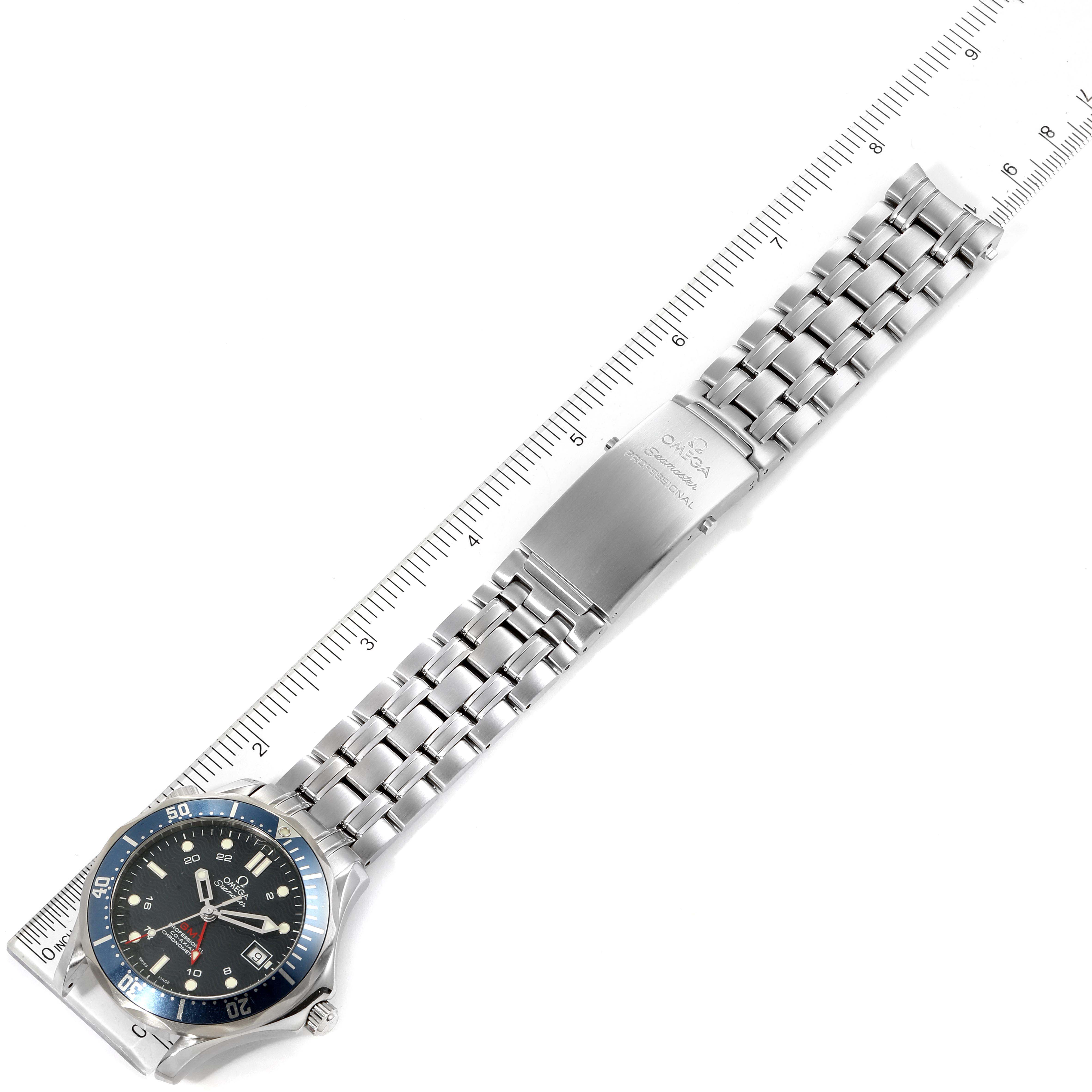 The image shows an overhead view of the Omega Seamaster 2535.80.00 Men
s Stainless Steel Blue Dial 2535.80.00 Men
s Stainless Steel Blue Dial watch, including its face, bracelet, and clasp measured against a ruler.
