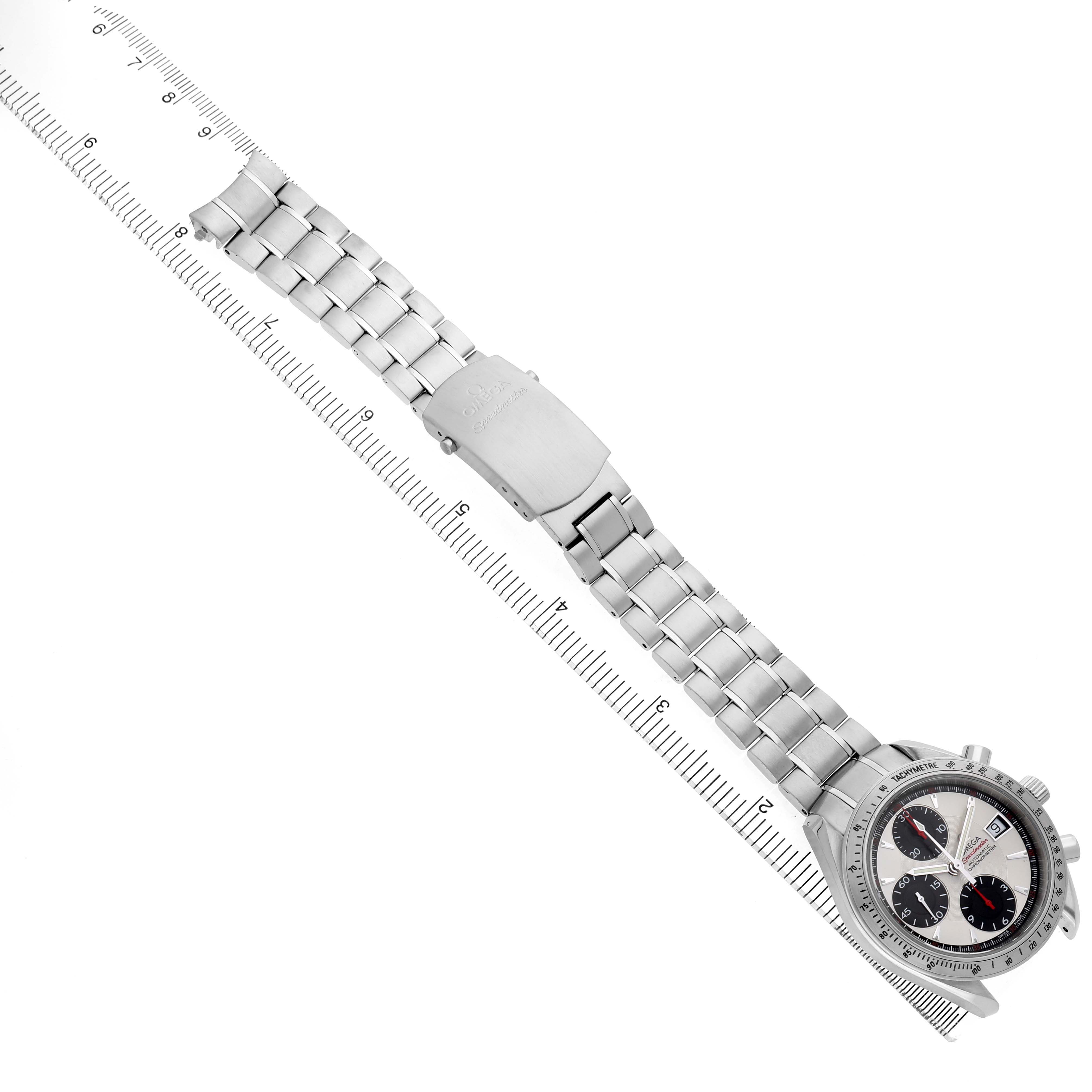 The Omega Speedmaster 3211.31.00 Men's Stainless Steel Silver Dial watch is shown from a top view, highlighting the dial, bracelet, and clasp along with a ruler for scale.