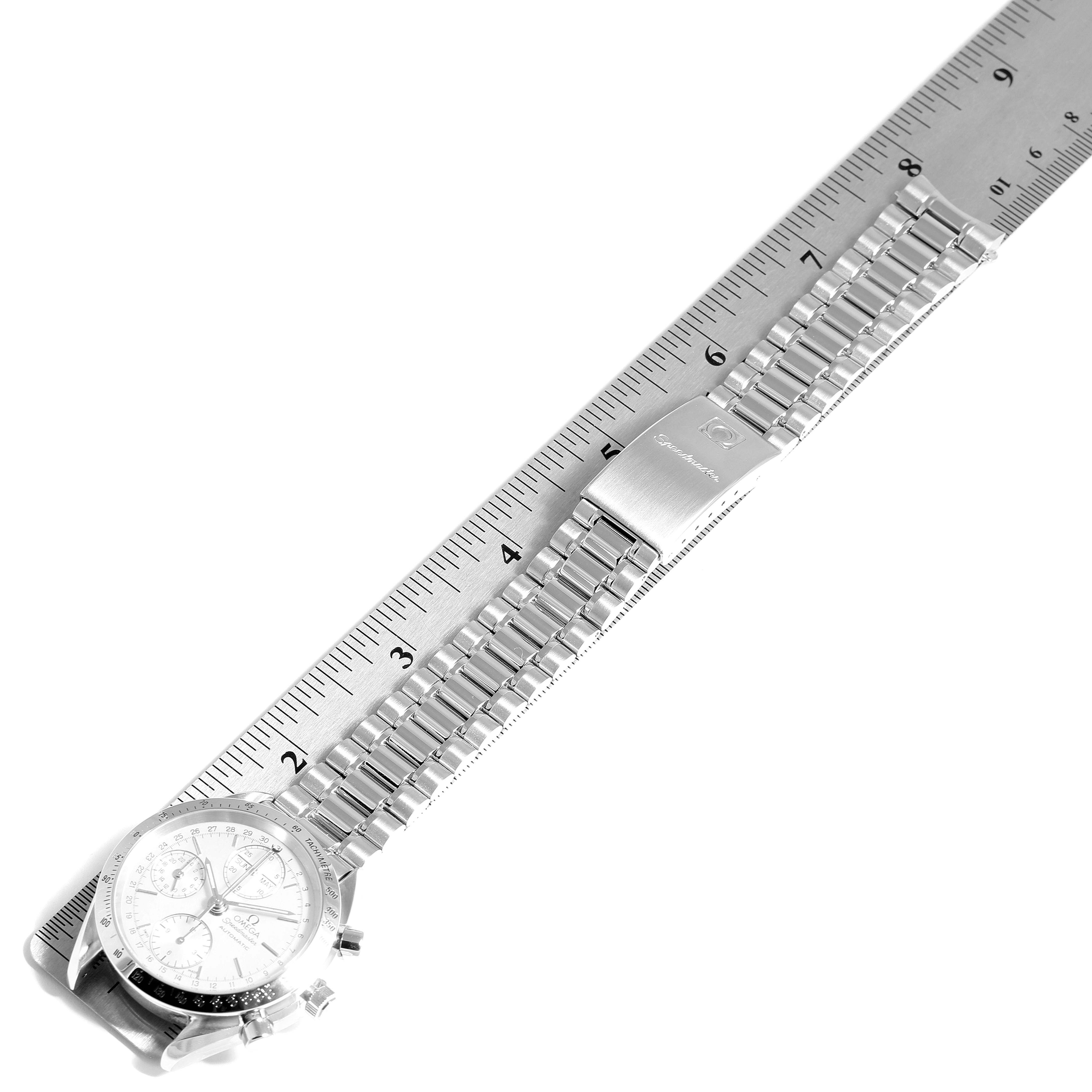 The image shows an Omega Speedmaster 3521.30.00 Men
s Stainless Steel Silver Dial 3521.30.00 Men
s Stainless Steel Silver Dial watch laid flat on a ruler, highlighting the bracelet and clasp.