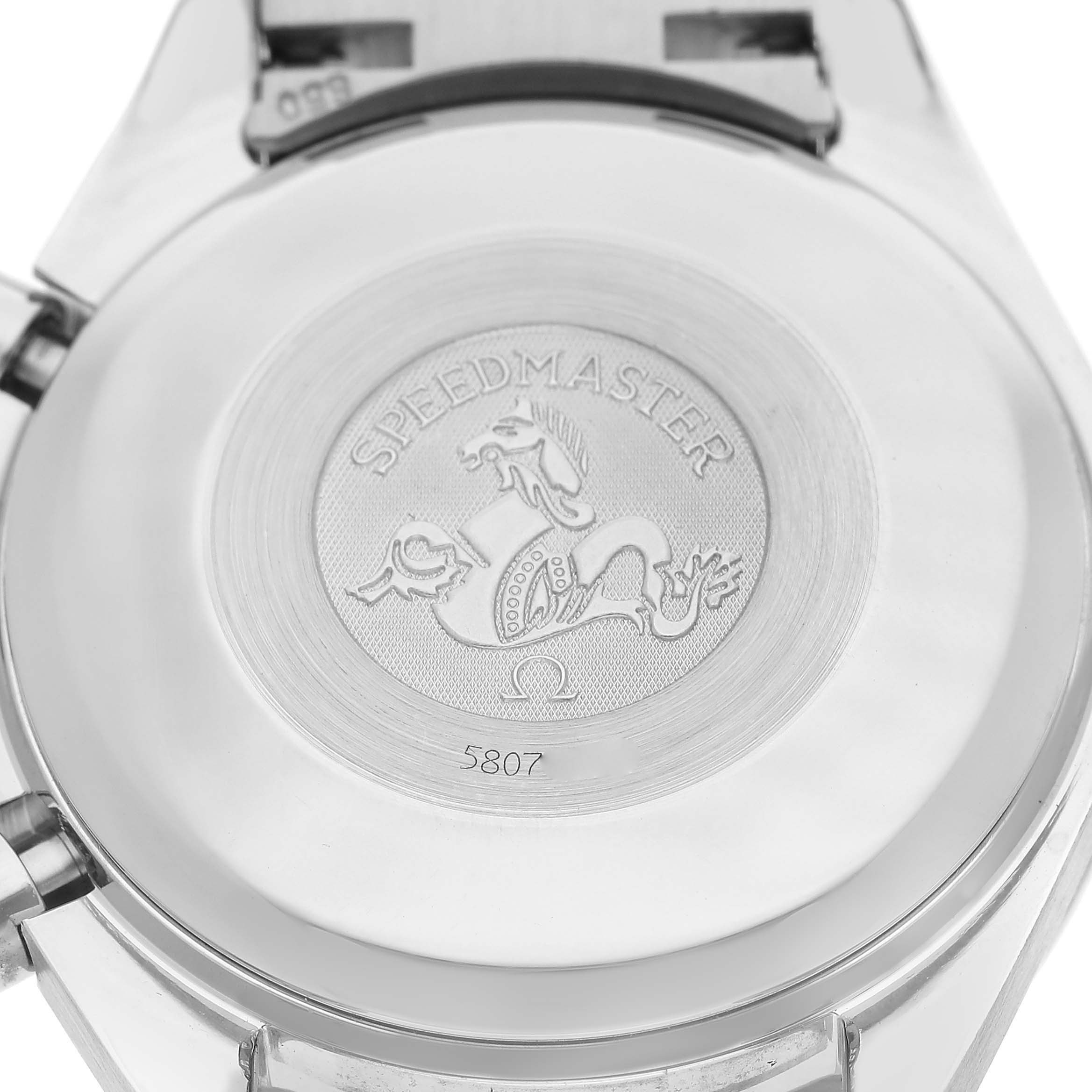The image shows the backside of an Omega Speedmaster 3523.30.00 Men's Stainless Steel Silver Dial watch, featuring an engraved emblem and the model name.
