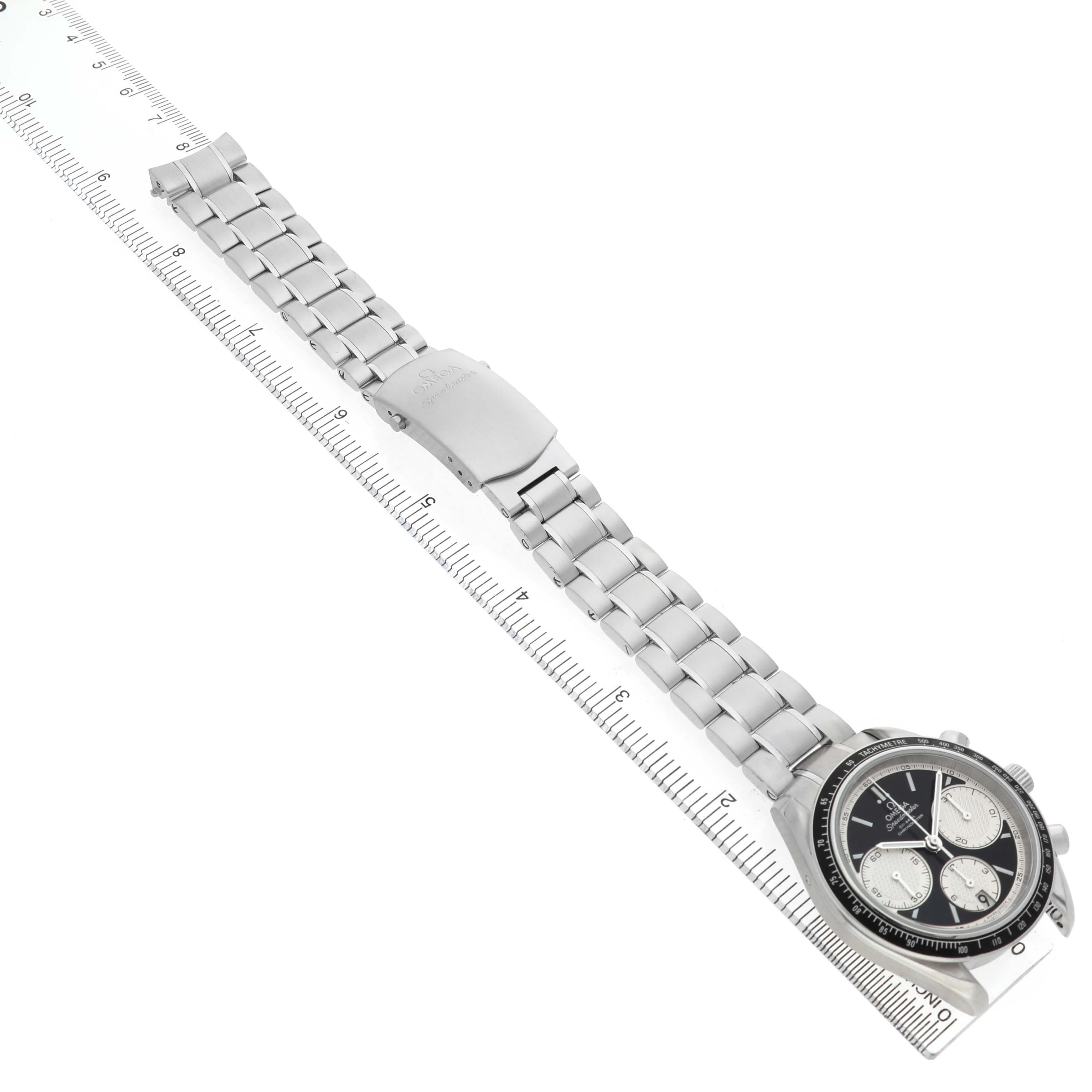 The Omega Speedmaster 326.30.40.50.01.002 Men's Stainless Steel Black Dial watch is shown from a top-down angle, displaying its full metal bracelet and face alongside a ruler.