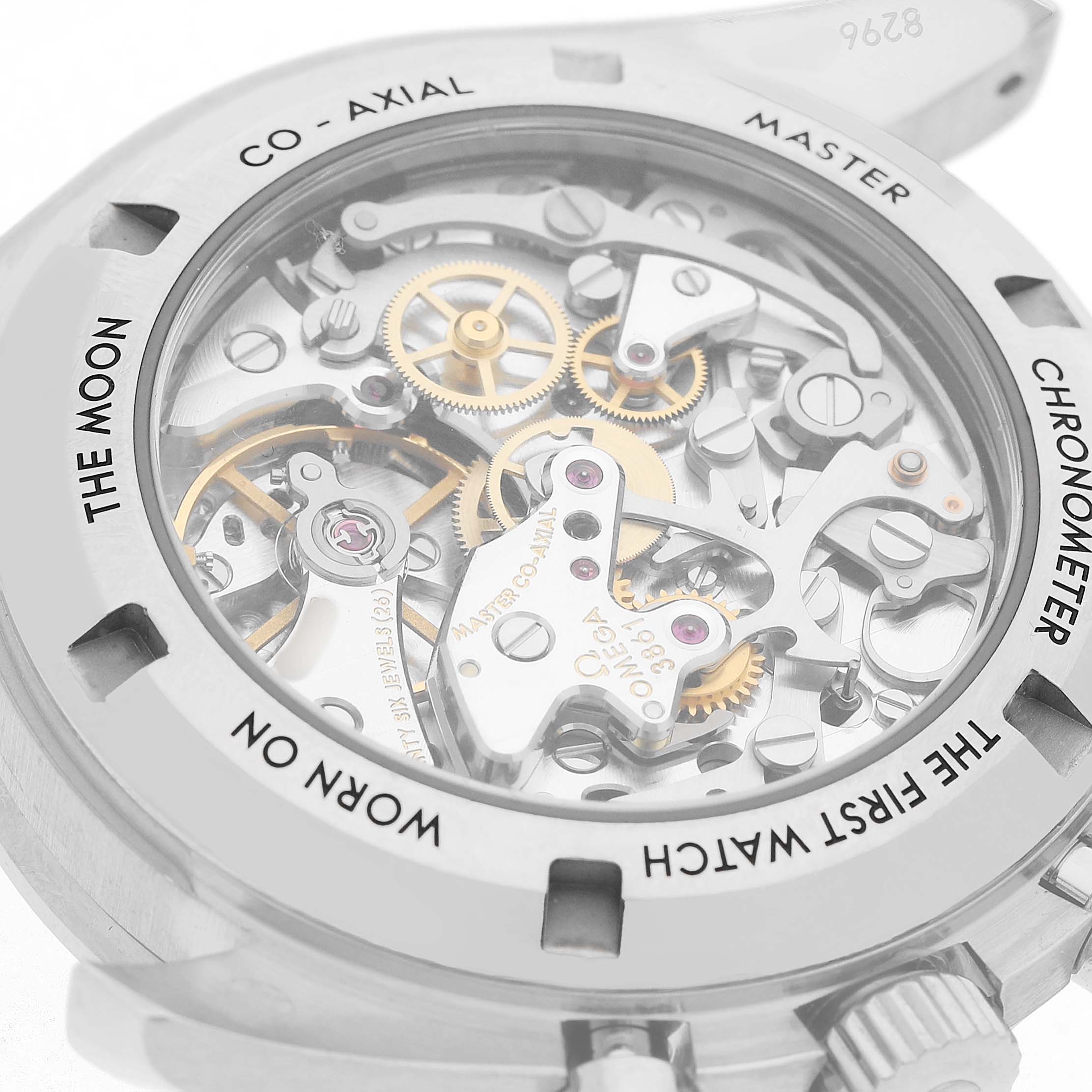 The image shows the case back of an Omega Speedmaster 310.60.42.50.02.001 Men's White Gold Silver Dial, highlighting its intricate movement and engravings.
