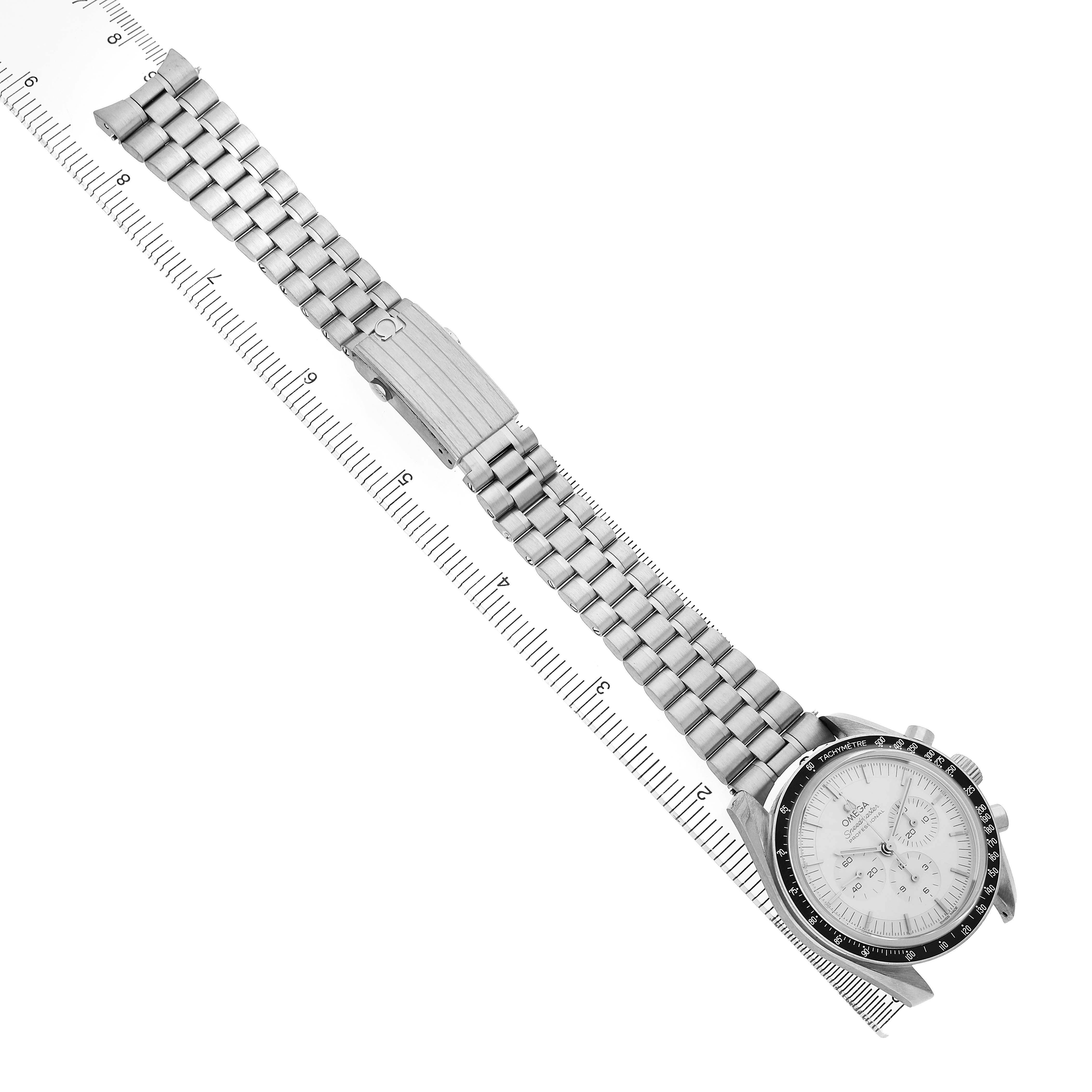The Omega Speedmaster 310.60.42.50.02.001 Men's White Gold Silver Dial is shown at an angle, highlighting its face and full metal bracelet with clasp, aligned with a ruler.