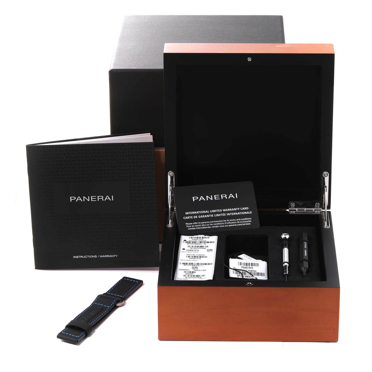 This image shows the open box and accessories for the Panerai Submersible PAM01973 Men's Stainless Steel Black Dial PAM01973 Men's Stainless Steel Black Dial watch, including a strap, booklet, and warranty card.