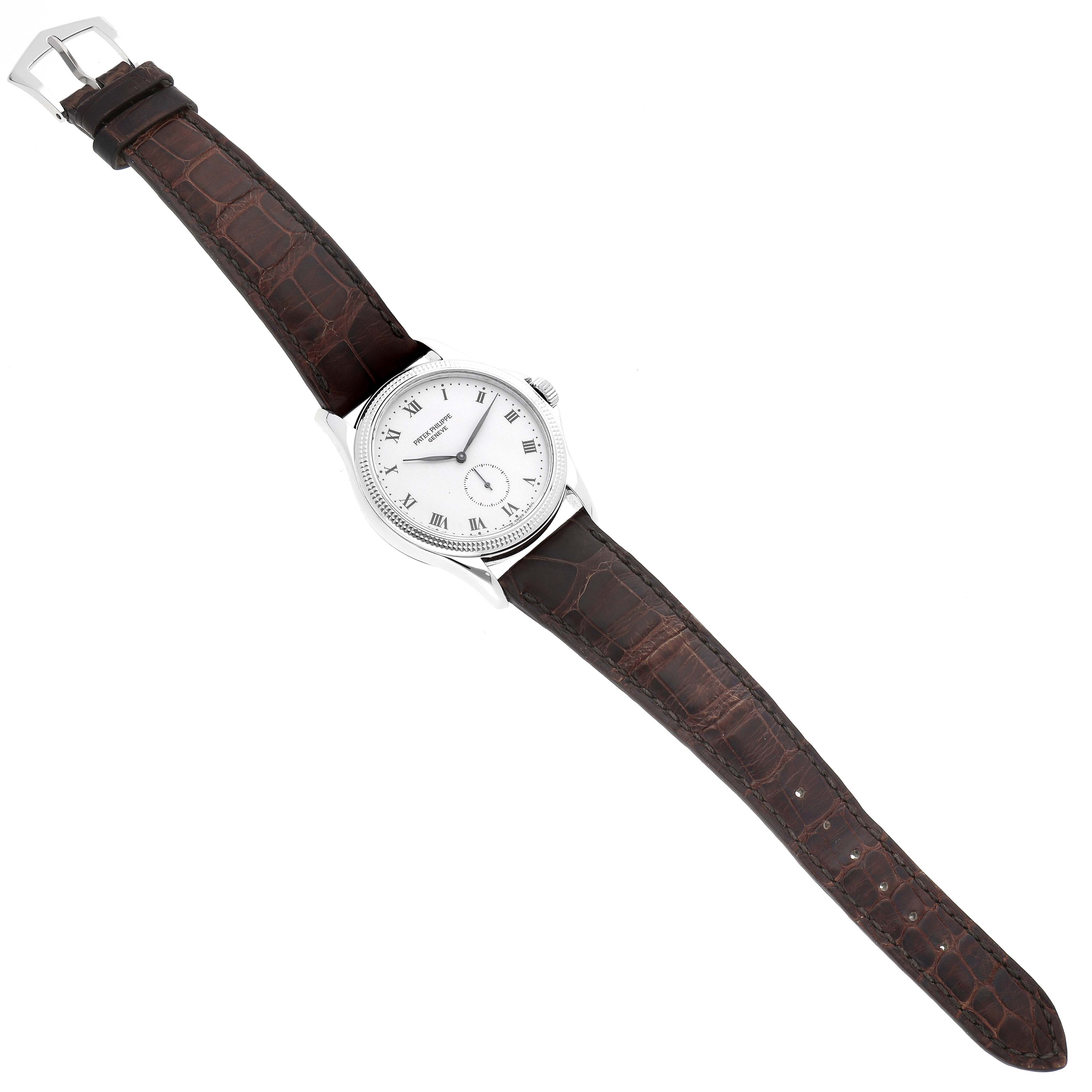 This Patek Philippe Calatrava 5115G Men's White Gold White Dial 5115G Men's White Gold White Dial watch is shown in a top-down angle highlighting its dial, case, and leather strap.