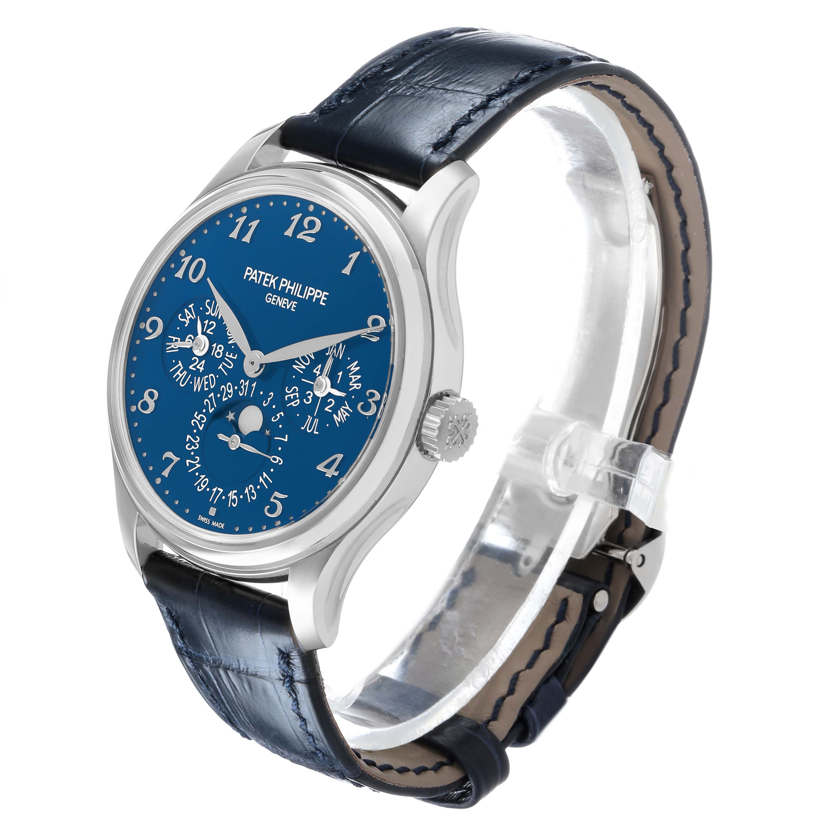 The Patek Philippe Complications 5327G Men's White Gold Blue Dial watch is shown at a three-quarter angle, highlighting the blue dial, silver case, and leather strap.