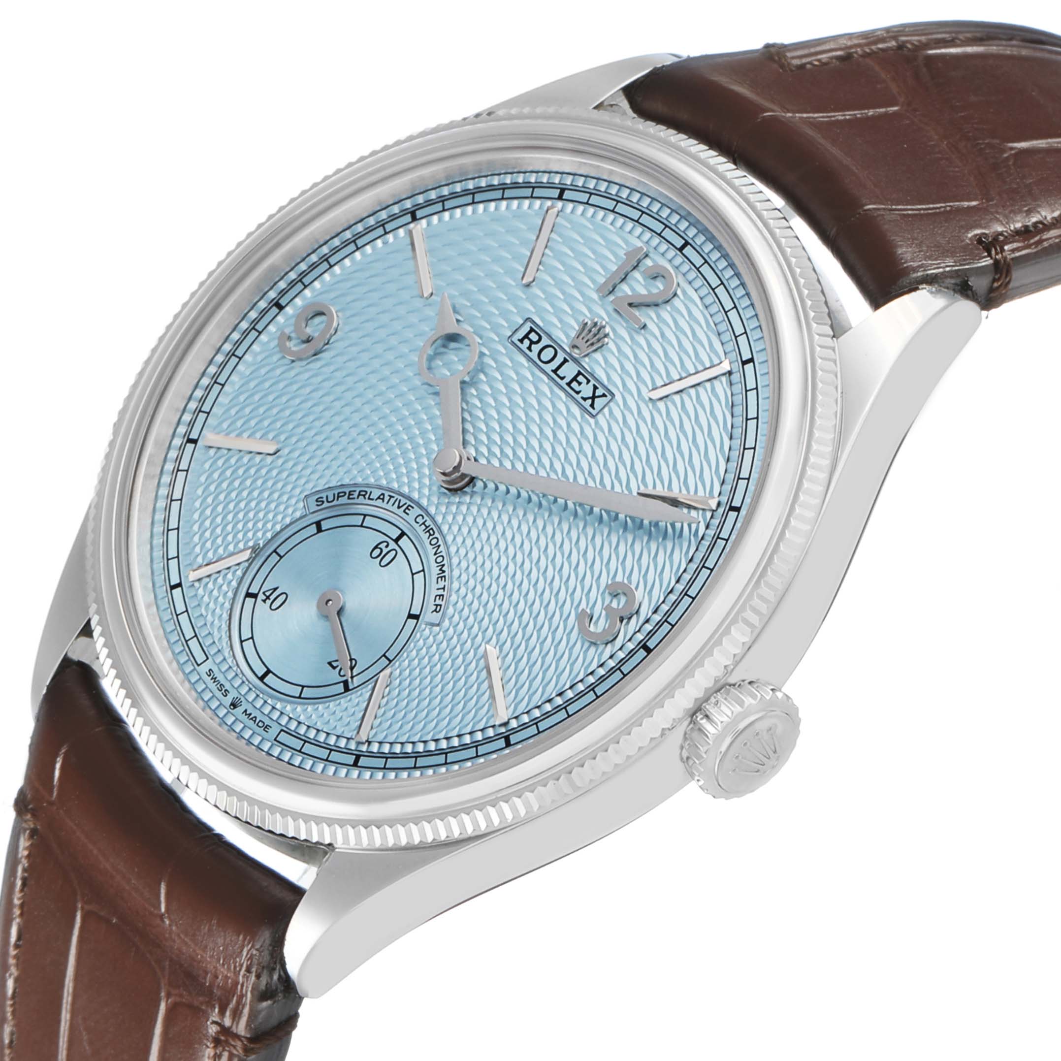 The image shows a side angle of a Rolex 1908 52506 Men's Platinum Blue Dial model, highlighting the blue dial, silver hands, bezel, and brown leather strap.