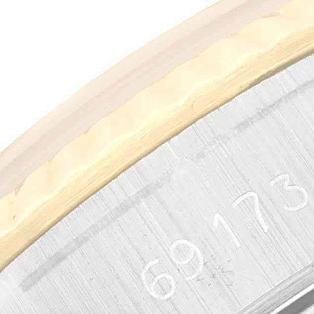 This close-up image shows the serial number engraving on the side of a Rolex Datejust 69173 Women's Steel and Gold (two tone) Black Dial 69173 Women's Steel and Gold (two tone) Black Dial watch case.