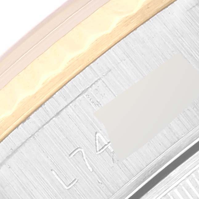 This image shows a close-up of the side of a Rolex Datejust 69173 Women's Steel and Gold (two tone) Black Dial 69173 Women's Steel and Gold (two tone) Black Dial watch, featuring part of the bezel and engraved serial number.