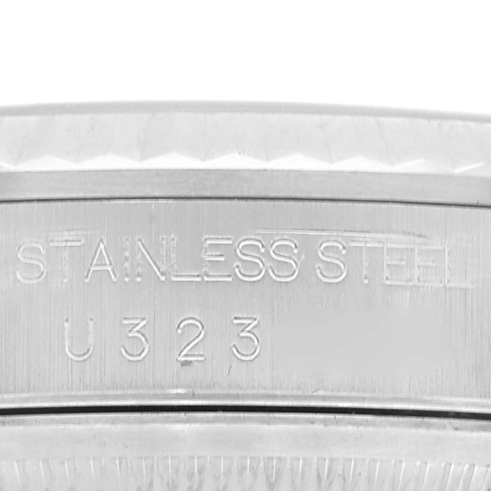 This image shows an extreme close-up of the case back engraving on the Rolex Datejust 16234 Men's Stainless Steel Black Dial 16234 Men's Stainless Steel Black Dial watch, displaying "STAINLESS STEEL" and a serial number.
