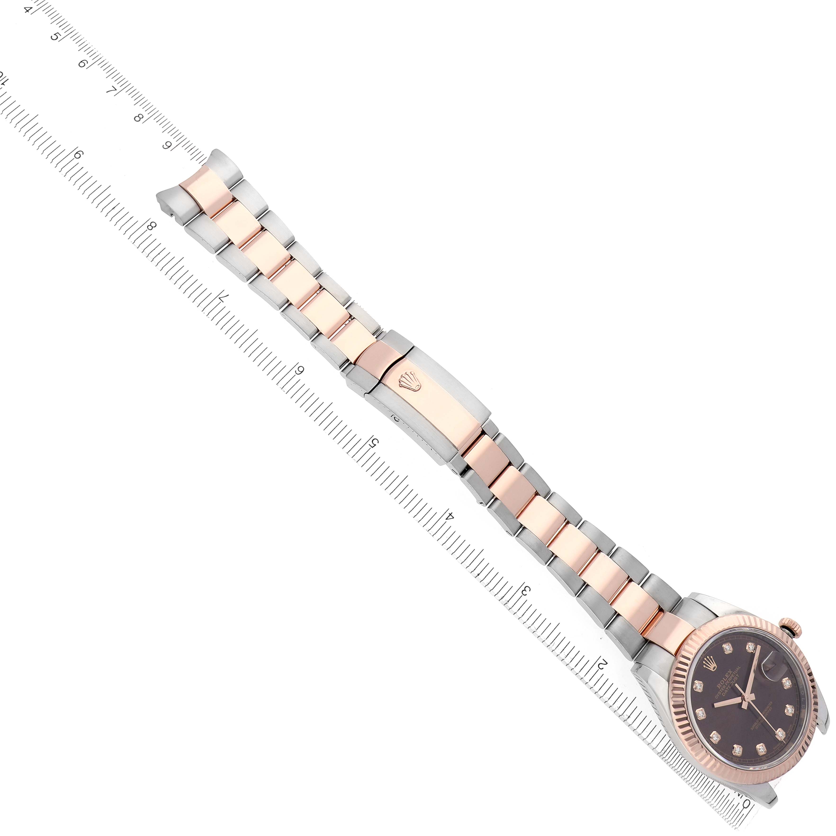 The Rolex Datejust 41 126331 Men
s Steel and Gold (two tone) Brown Dial 126331 Men
s Steel and Gold (two tone) Brown Dial watch is shown in a diagonal angle, highlighting the bracelet, case, and clasp alongside a ruler for scale.