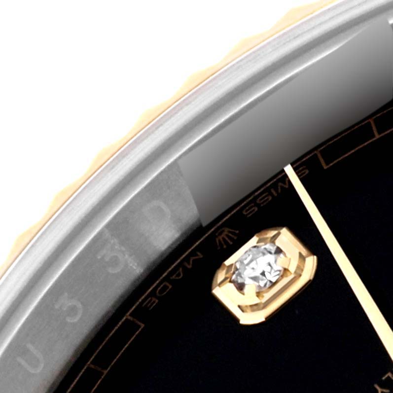 This close-up of a Rolex Datejust 41 126333 Men's Steel and Gold (two tone) Black Dial 126333 Men's Steel and Gold (two tone) Black Dial watch highlights its bezel, diamond hour marker, and part of the dial.