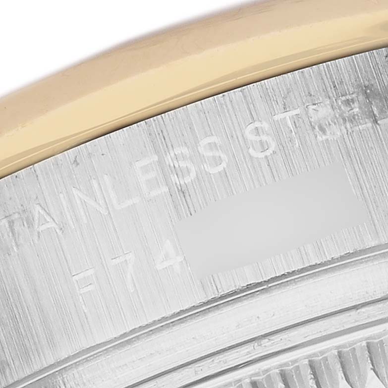 This close-up image shows the case back of a Rolex Datejust 179163 Women's Steel and Gold (two tone) Silver Dial 179163 Women's Steel and Gold (two tone) Silver Dial watch, including parts of the stainless steel and markings.