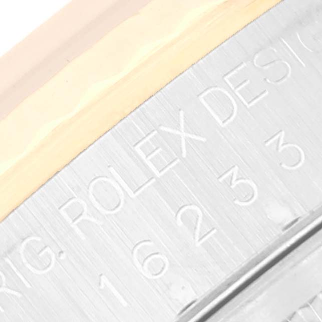 This image shows an angled close-up of the side of a Rolex Datejust 16233 Men's Steel and Gold (two tone) Champagne Dial 16233 Men's Steel and Gold (two tone) Champagne Dial watch, highlighting the engraving "ROLEX DESIGN" and part of the serial number.
