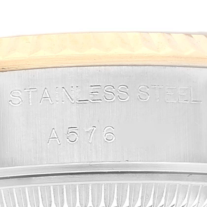 Close-up of the outer rim and the side of the case back of a Rolex Datejust 79173 Women's Steel and Gold (two tone) Champagne Dial 79173 Women's Steel and Gold (two tone) Champagne Dial watch, showing "STAINLESS STEEL" and a serial number.