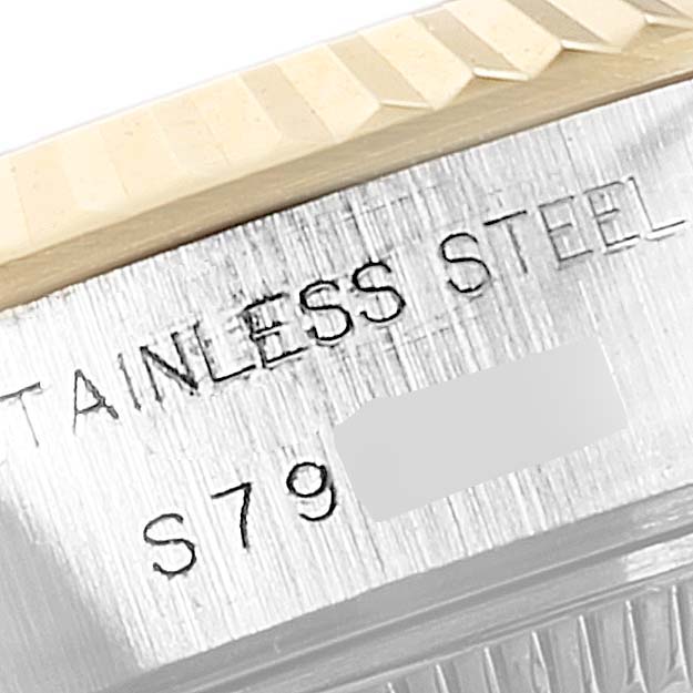 The image shows the side view of a Rolex Datejust 69173 Women's Steel and Gold (two tone) Brown Dial 69173 Women's Steel and Gold (two tone) Brown Dial watch, highlighting the stainless steel part with engraved text and a portion of the bezel.