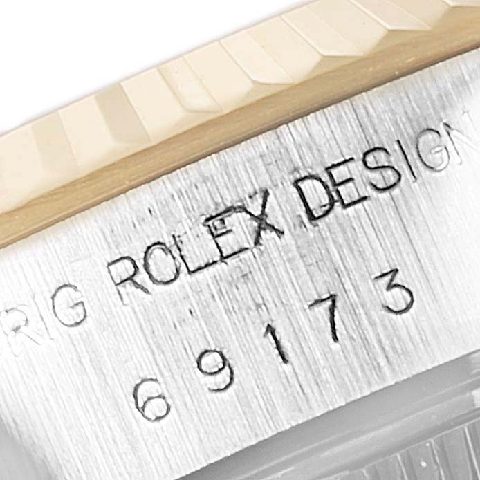 This close-up image shows the model number and "ORIG ROLEX DESIGN" engraving on the side of a Rolex Datejust 69173 Women's Steel and Gold (two tone) Brown Dial 69173 Women's Steel and Gold (two tone) Brown Dial watch case.