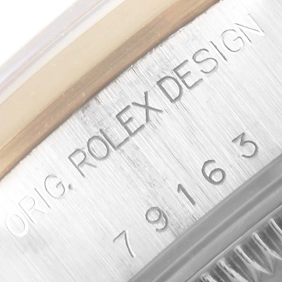 This close-up image shows the serial number engraving on the case of a Rolex Datejust 79163 Women's Steel and Gold (two tone) Grey Dial 79163 Women's Steel and Gold (two tone) Grey Dial watch.