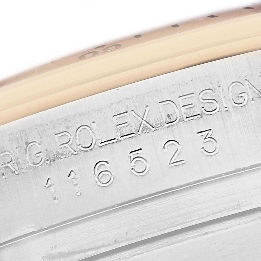 The image shows a close-up of the engraved side of the Rolex Daytona 116523 Men
s Steel and Gold (two tone) Mother of Pearl Dial 116523 Men
s Steel and Gold (two tone) Mother of Pearl Dial, highlighting the model number and the "Rolex Design" text.