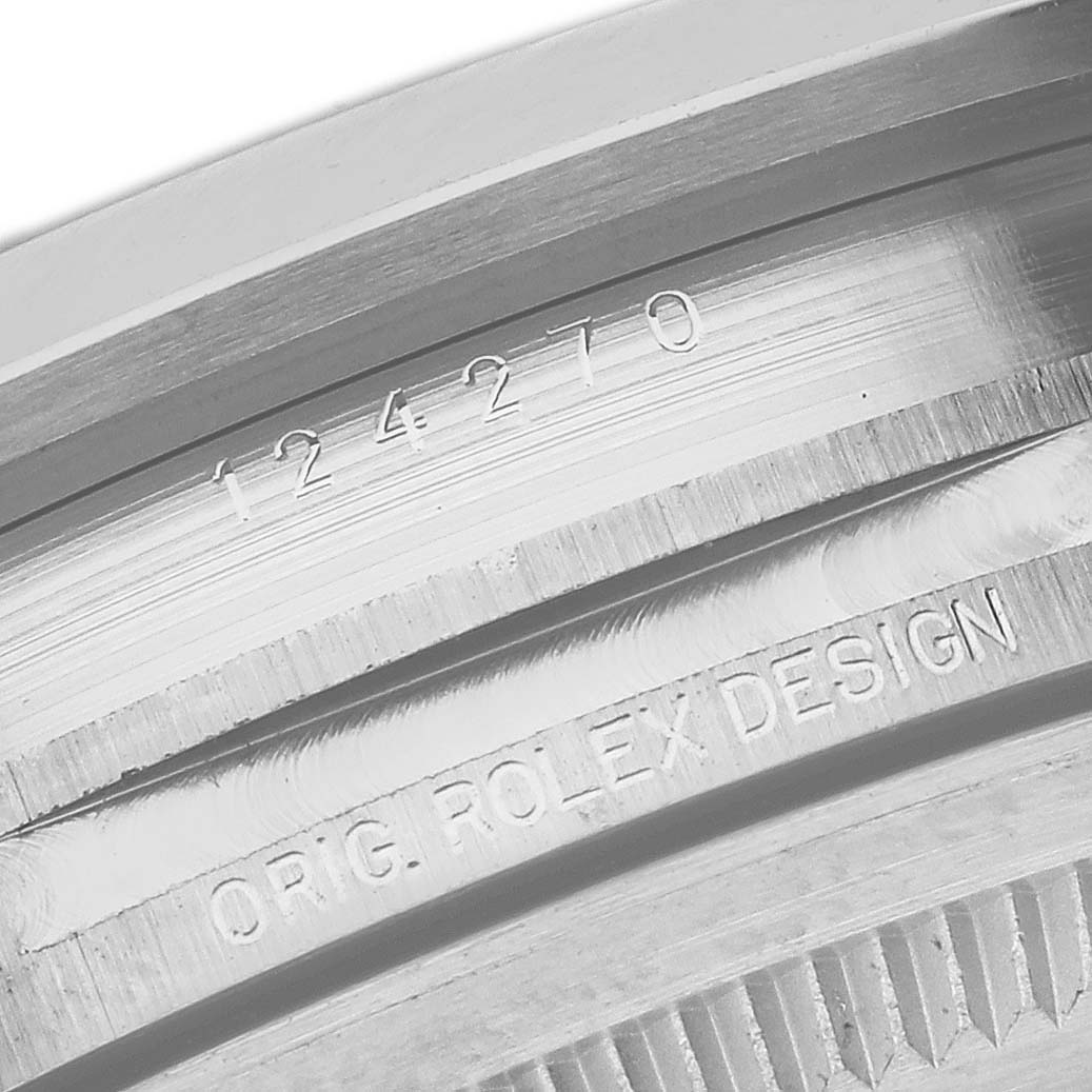 The close-up image shows the engraved serial number and "ORIG. ROLEX DESIGN" on the case of a Rolex Explorer 124270 Men
s Stainless Steel Black Dial 124270 Men
s Stainless Steel Black Dial model 124270.