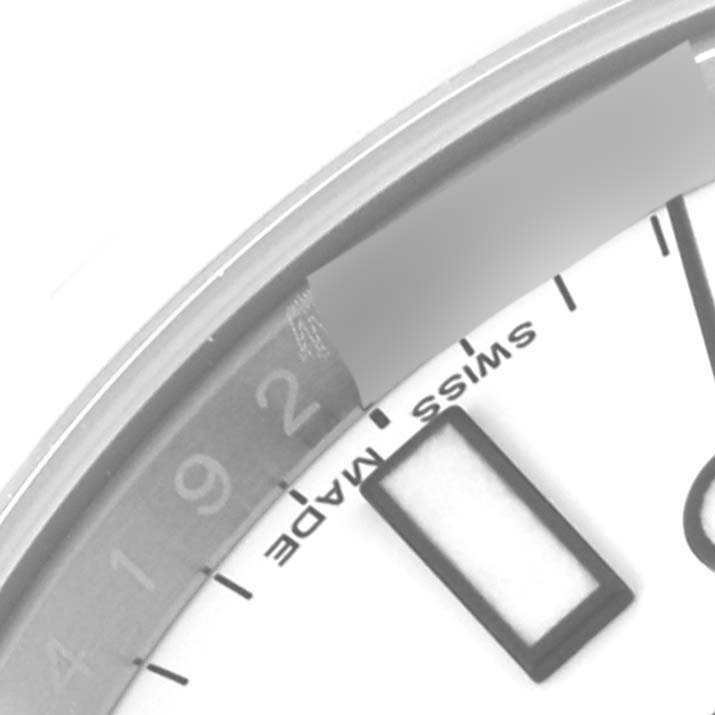 This image shows a close-up of the Rolex Explorer 216570 Men
s Stainless Steel White Dial 216570 Men
s Stainless Steel White Dial
s dial featuring part of the hour markers and the "SWISS MADE" text.