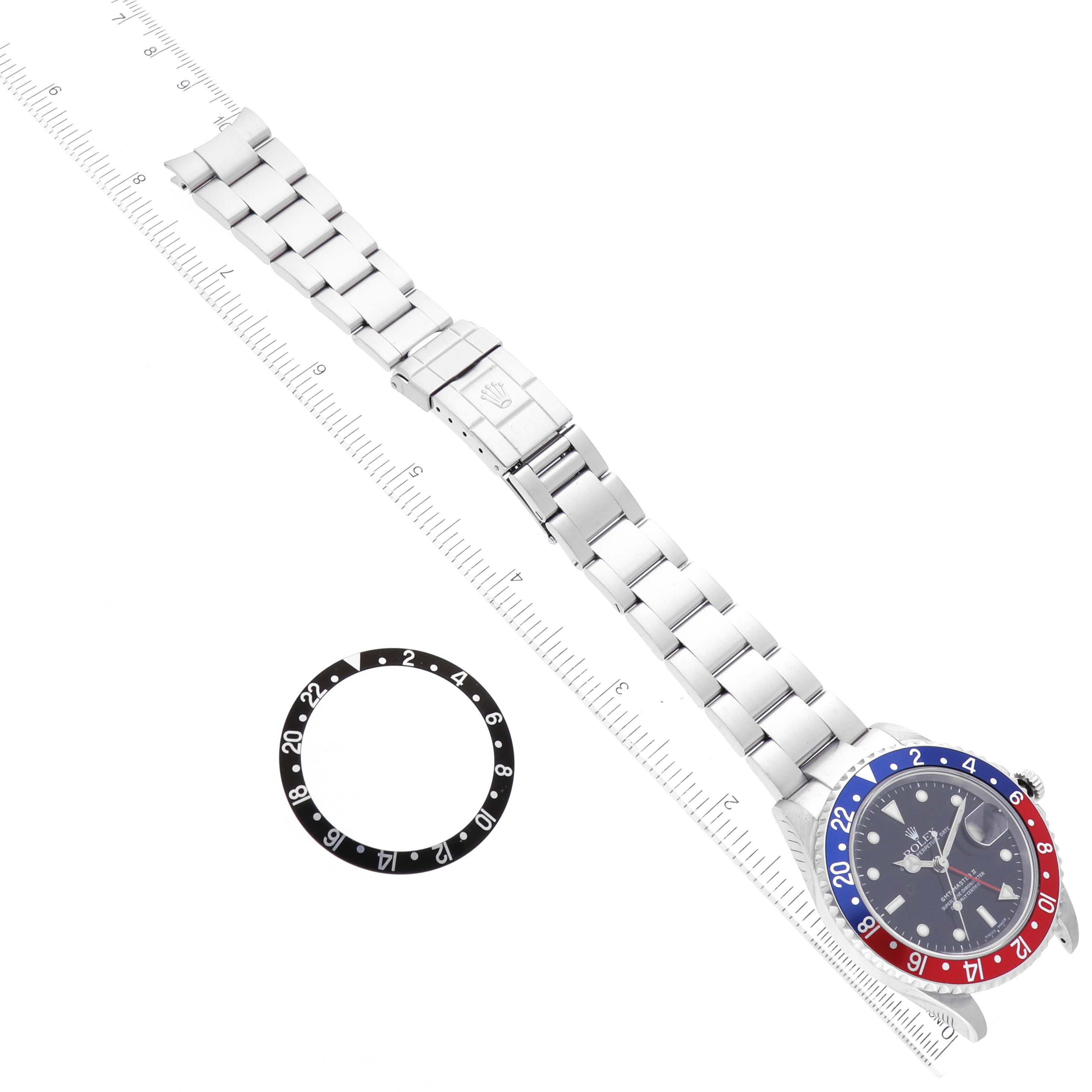 The image shows a top-down view of a Rolex GMT-Master 16710 Men's Stainless Steel Black Dial 16710 Men's Stainless Steel Black Dial watch and an additional bezel ring.