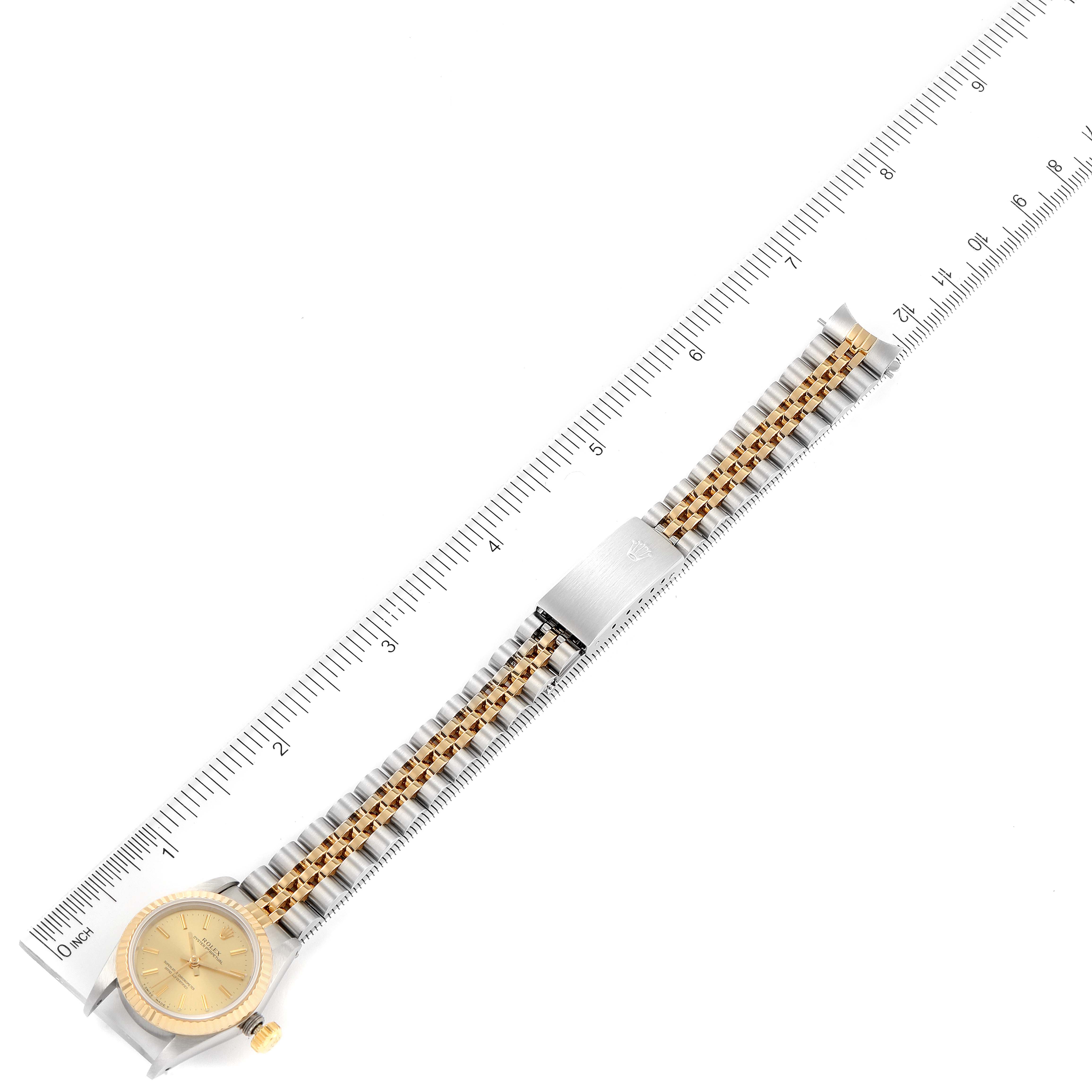 The image shows an overhead view of a Rolex Oyster Perpetual 67193 Women
s Steel and Gold (two tone) Champagne Dial 67193 Women
s Steel and Gold (two tone) Champagne Dial watch including its face, bezel, and full bracelet.