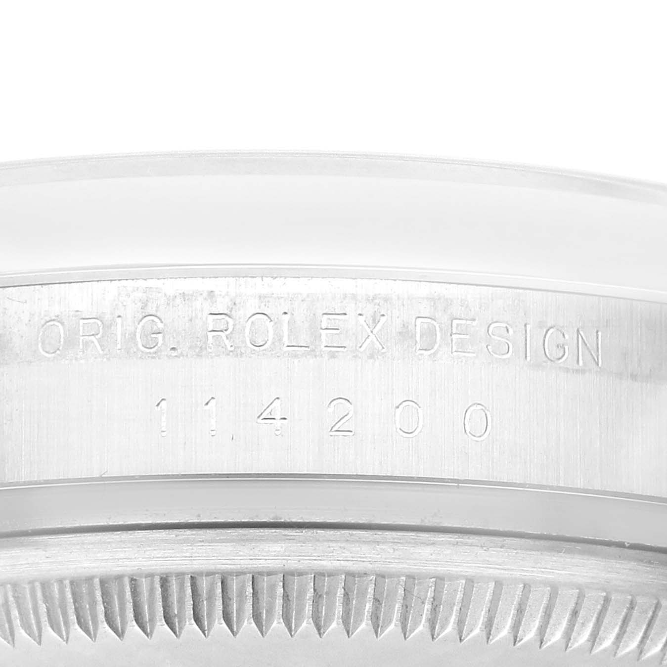 This image shows a close-up of the bezel and serial number engraving on a Rolex Oyster Perpetual 114200 Men
s Stainless Steel Silver Dial 114200 Men
s Stainless Steel Silver Dial model.