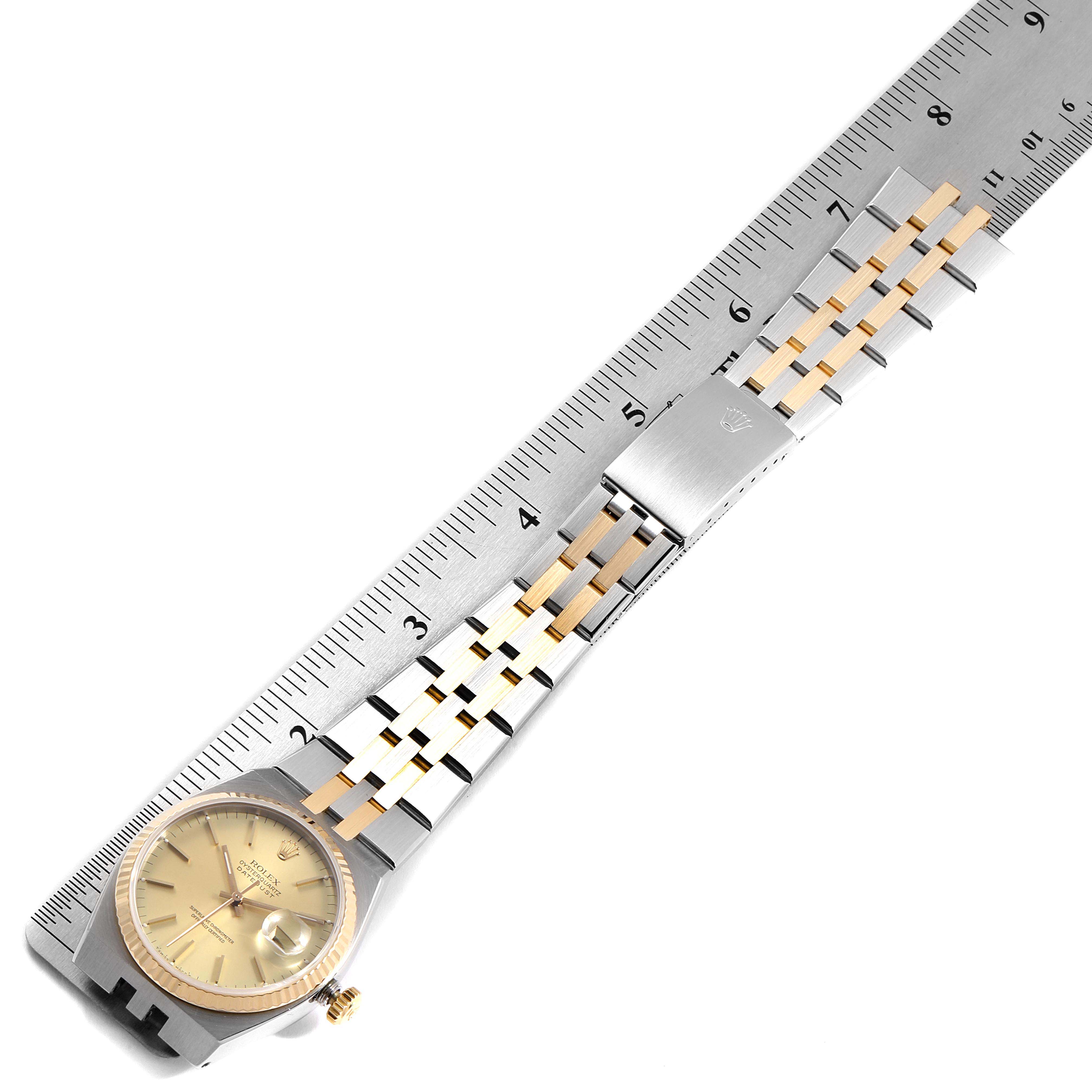 The image shows a Rolex Oysterquartz 17013 Men
s Steel and Gold (two tone) Champagne Dial 17013 Men
s Steel and Gold (two tone) Champagne Dial watch laid flat with a ruler, highlighting the dial, crown, and bracelet.