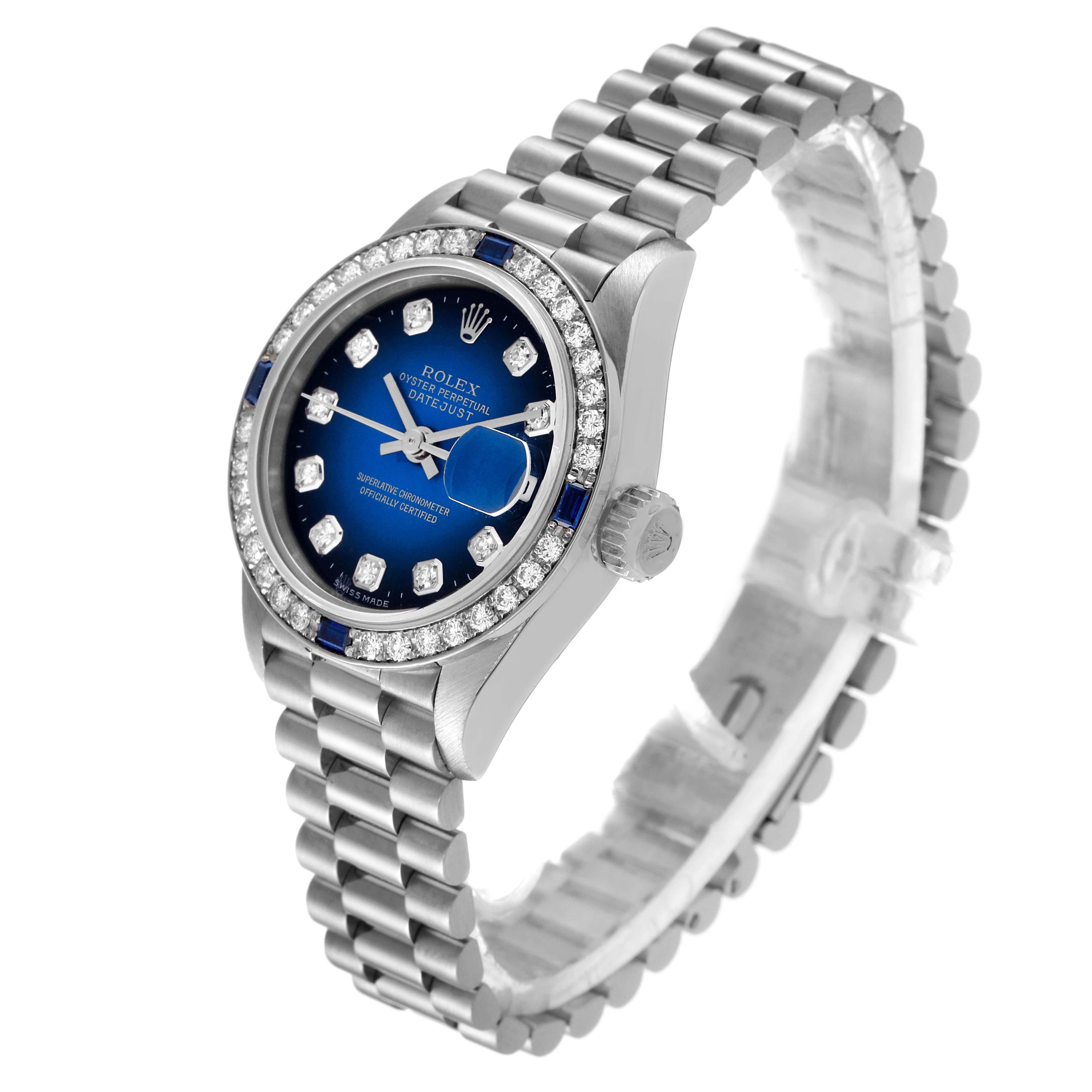 The image shows a Rolex President 79089 Women's White Gold Blue Dial 79089 Women's White Gold Blue Dial model watch angled to display its blue dial, diamond bezel, and bracelet.