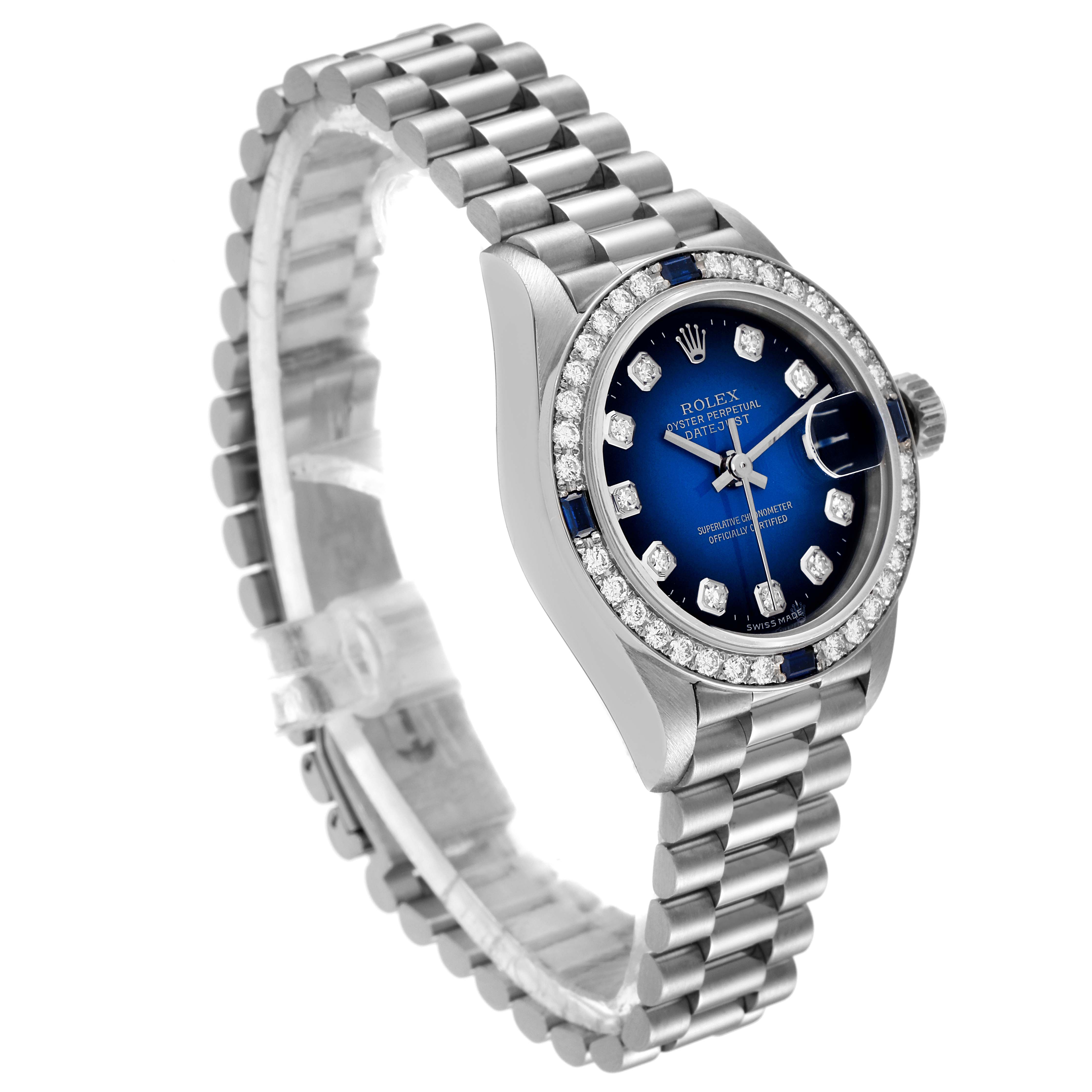 The image shows a side angle of the Rolex President 79089 Women's White Gold Blue Dial 79089 Women's White Gold Blue Dial model watch, featuring its bracelet, blue dial, and diamond bezel.
