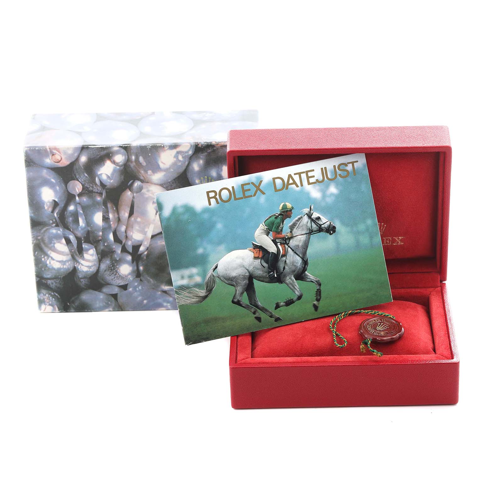 The image shows a Rolex President 69179 Women
s White Gold White Dial 69179 Women
s White Gold White Dial watch box with a booklet and a tag, viewed from the front.