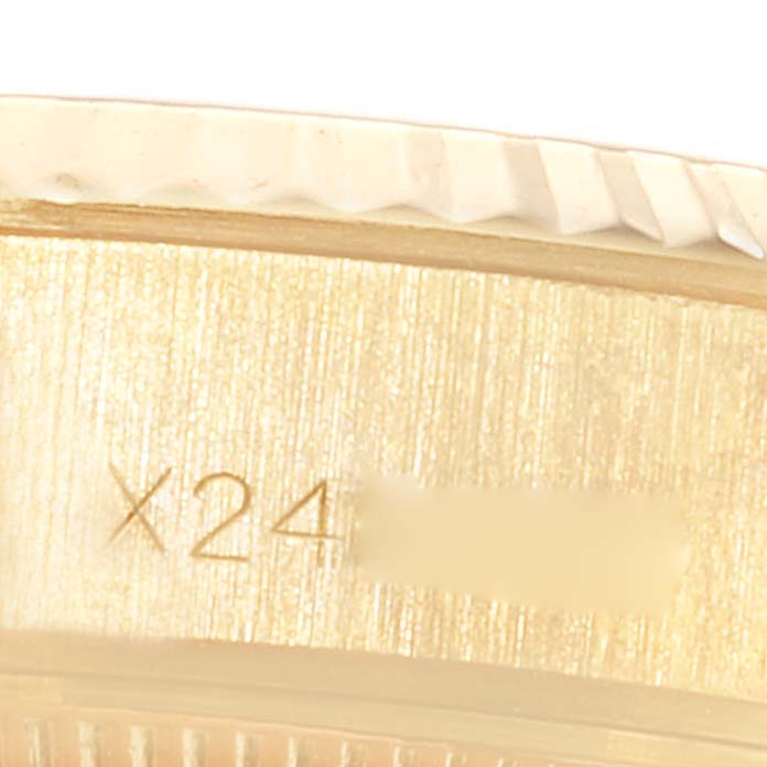 This close-up image shows part of the side of a Rolex President 69178 Women
s Yellow Gold Champagne Dial 69178 Women
s Yellow Gold Champagne Dial model watch, specifically highlighting engraved text.