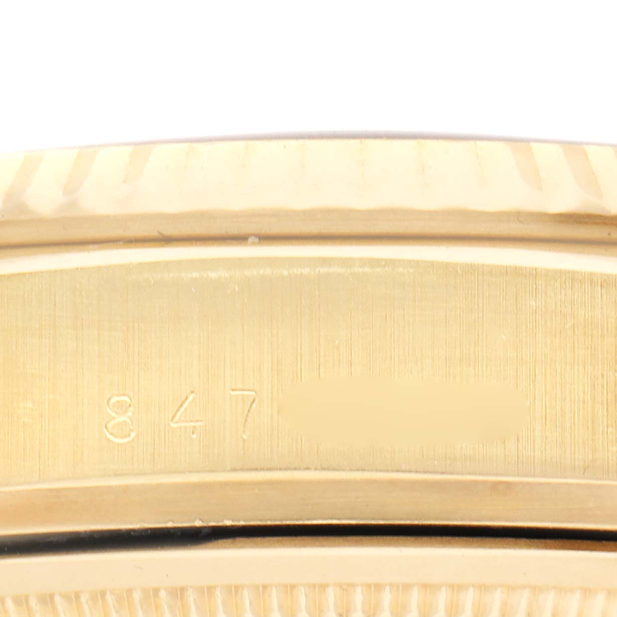 The image shows a close-up of the side of a Rolex President 18038 Men
s Yellow Gold White Dial 18038 Men
s Yellow Gold White Dial watch, highlighting part of the bracelet and engraved numbers.