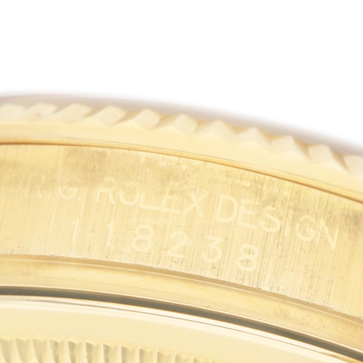 This image shows a close-up of the side engraving on a Rolex President 118238 Men's Yellow Gold Champagne Dial model, focusing on its bezel and case edge.