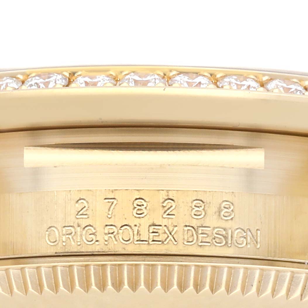 The image shows the side view of a Rolex Mid-Size model, focusing on the bezel with diamond detailing and engraved text.