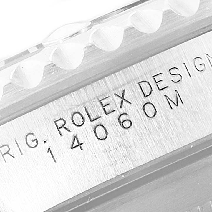 This close-up image shows the engraved model number and edge of the bezel of a Rolex Submariner 14060M Men
s Stainless Steel Black Dial 14060M Men
s Stainless Steel Black Dial watch.