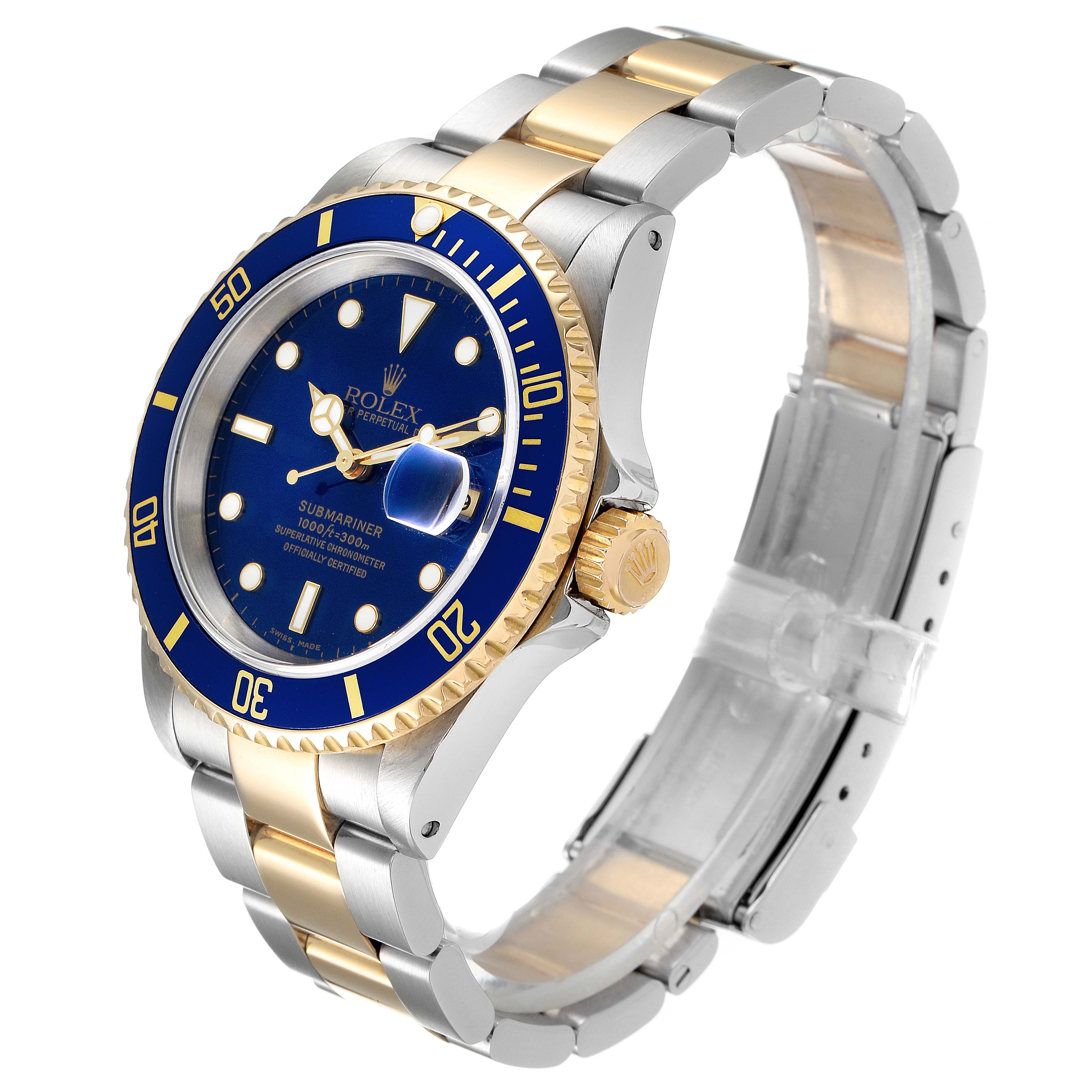 The image shows an angled view of a Rolex Submariner 16613 Men
s Steel and Gold (two tone) Blue Dial 16613 Men
s Steel and Gold (two tone) Blue Dial watch, highlighting its blue dial, bezel, and two-tone bracelet.
